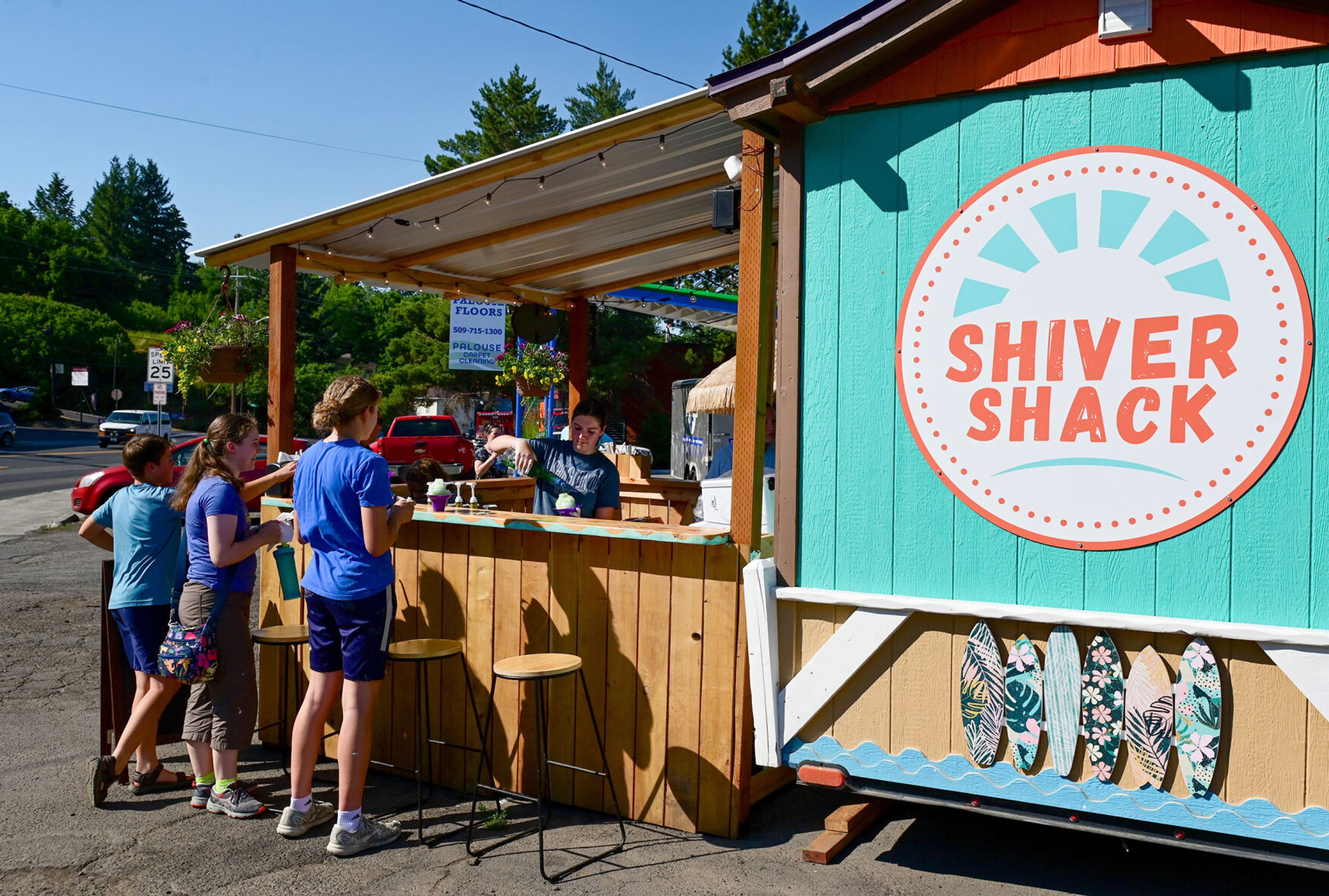 Manager Addyson Fitzgerald, right, fills snow cone orders for those waiting along the edge of the Shiver Shack in Pullman on Tuesday.