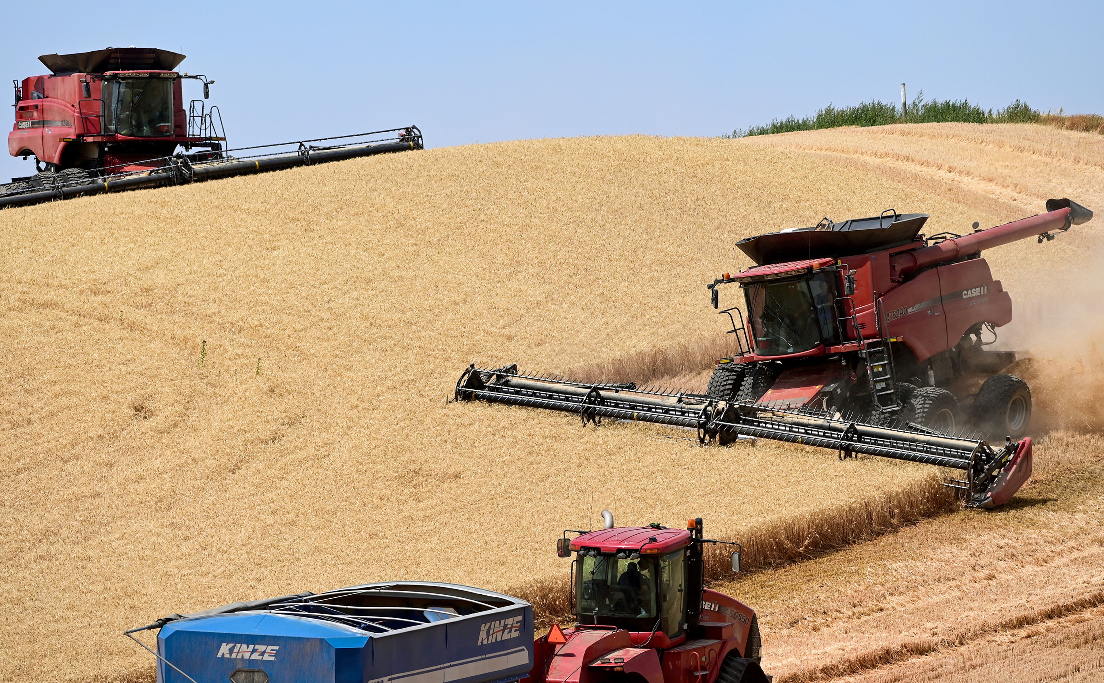 Combines work to harvest a field on Monday along Highway 195 north of Colfax.