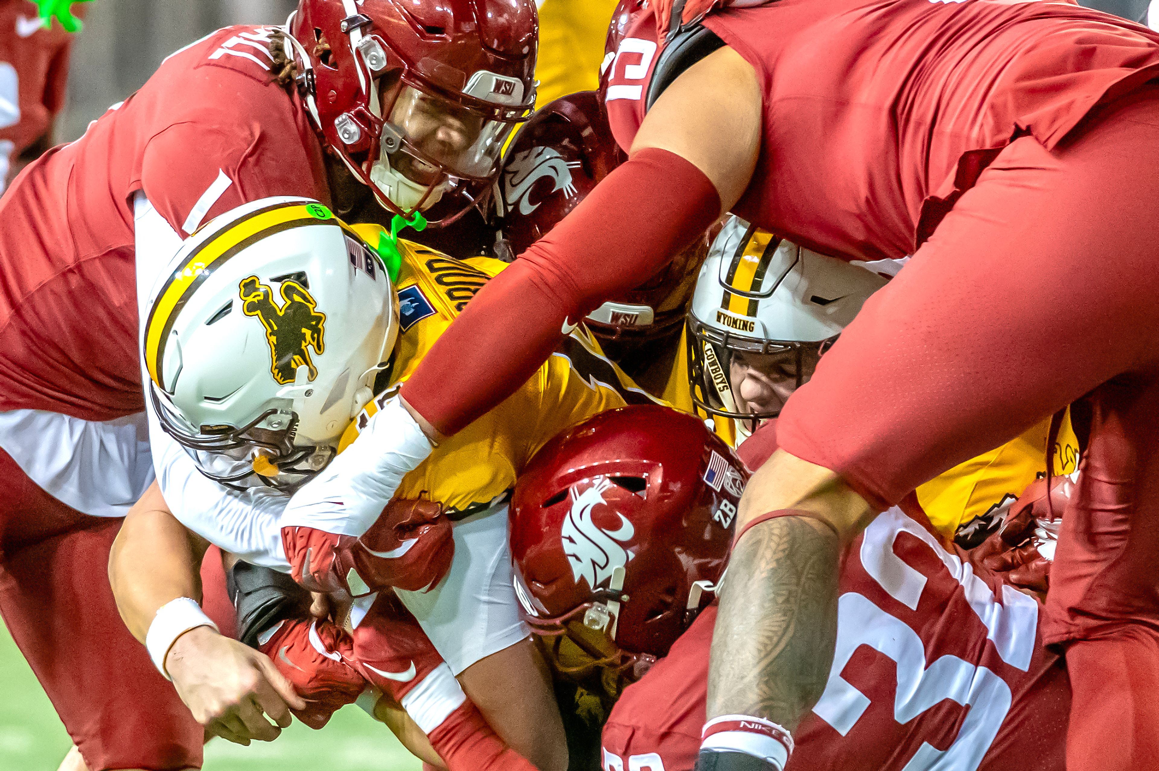 Wyoming quarterback Evan Svoboda is tackled by numerous Washington State players during a quarter of a college football game on Saturday, at Gesa Field in Pullman. Wyoming defeated Washington State 15-14.