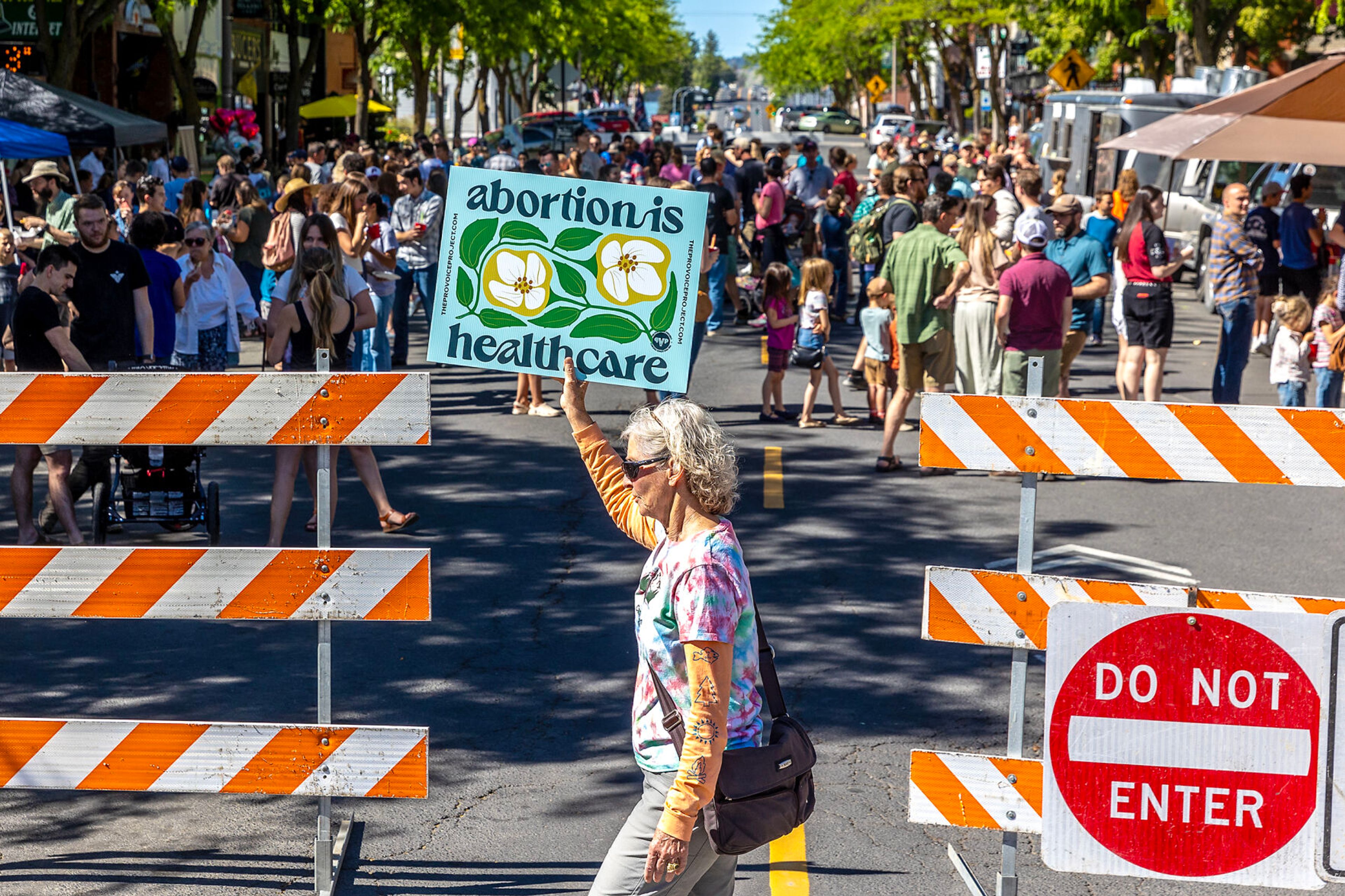 A counter protesters walks by with a sign as people celebrate the anniversary of the overturning of Roe v. Wade with a block party on Main Street Monday in Moscow.