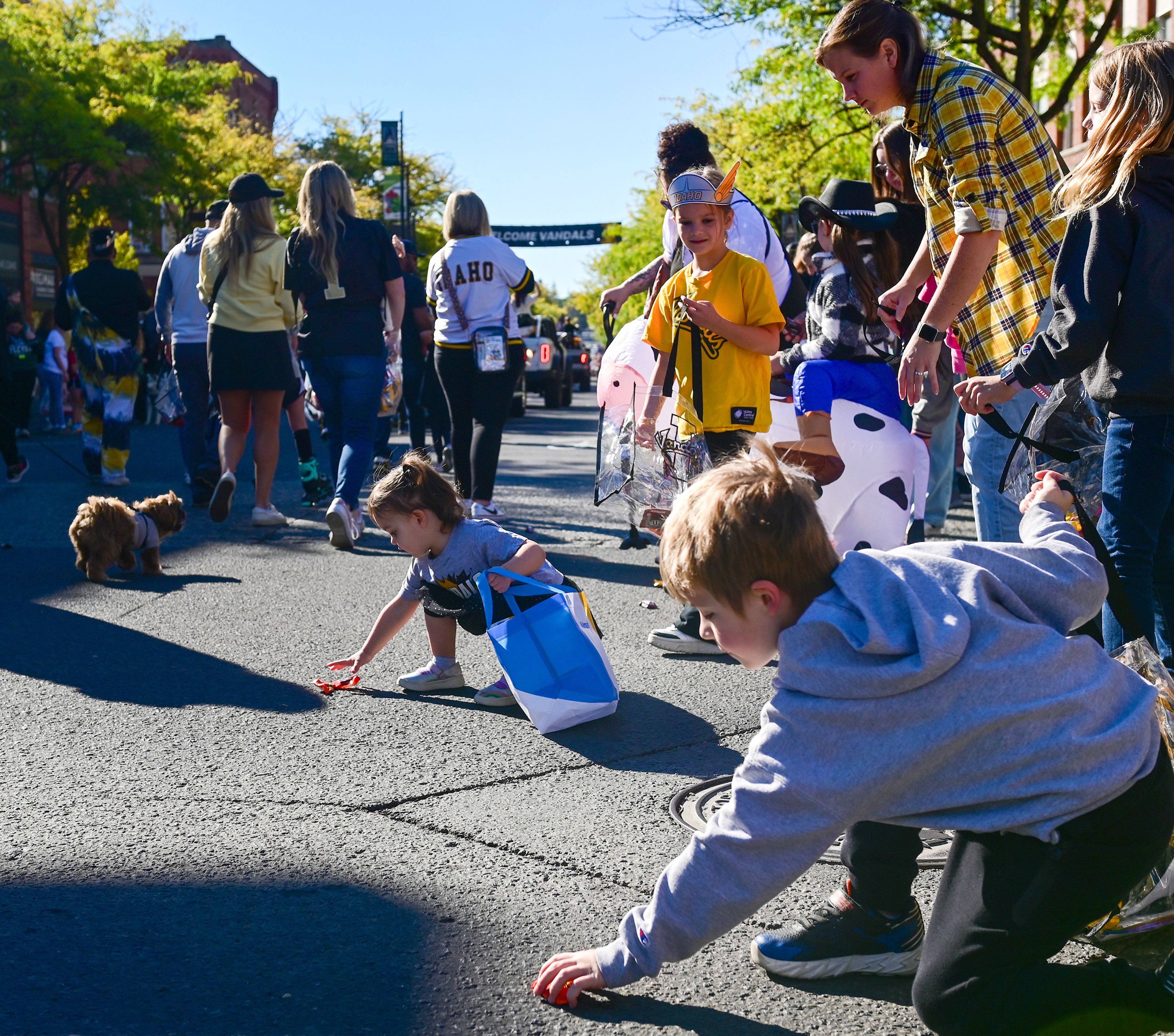 Young attendees of the parade pick up candy thrown from passing floats along Main Street Saturday in Moscow.