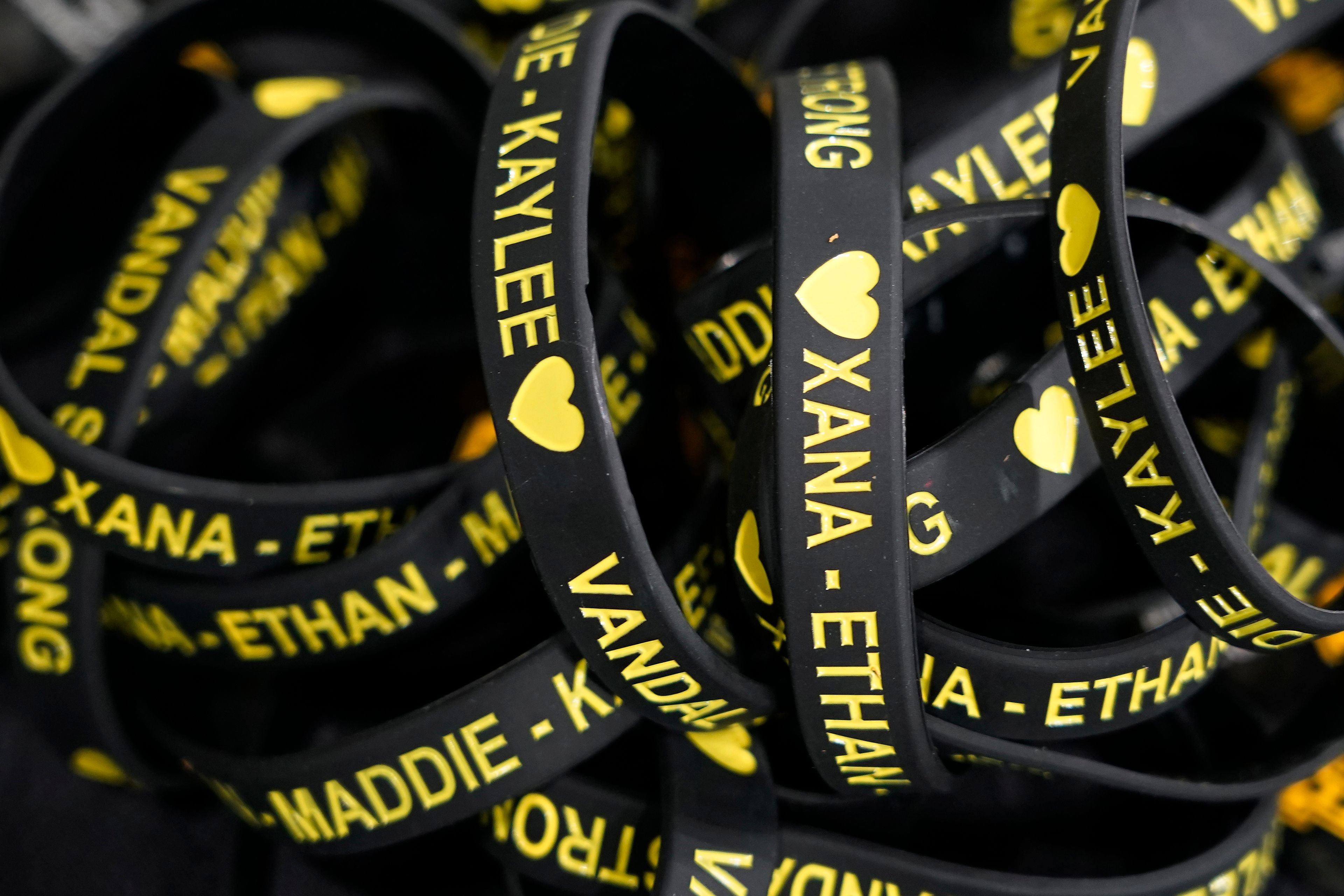 FILE - Bracelets with the names of the four University of Idaho students who were killed on Nov. 13, 2022, are displayed on a table at a vigil for the victims, Wednesday, Nov. 30, 2022, in Moscow, Idaho. Investigators have yet to name a suspect in the stabbing deaths of four University of Idaho students who were found dead in a home near campus last month. But would-be armchair detectives and internet sleuths have come up with several of their own, the conclusions often based on conjecture and rumor. (AP Photo/Ted S. Warren, File)