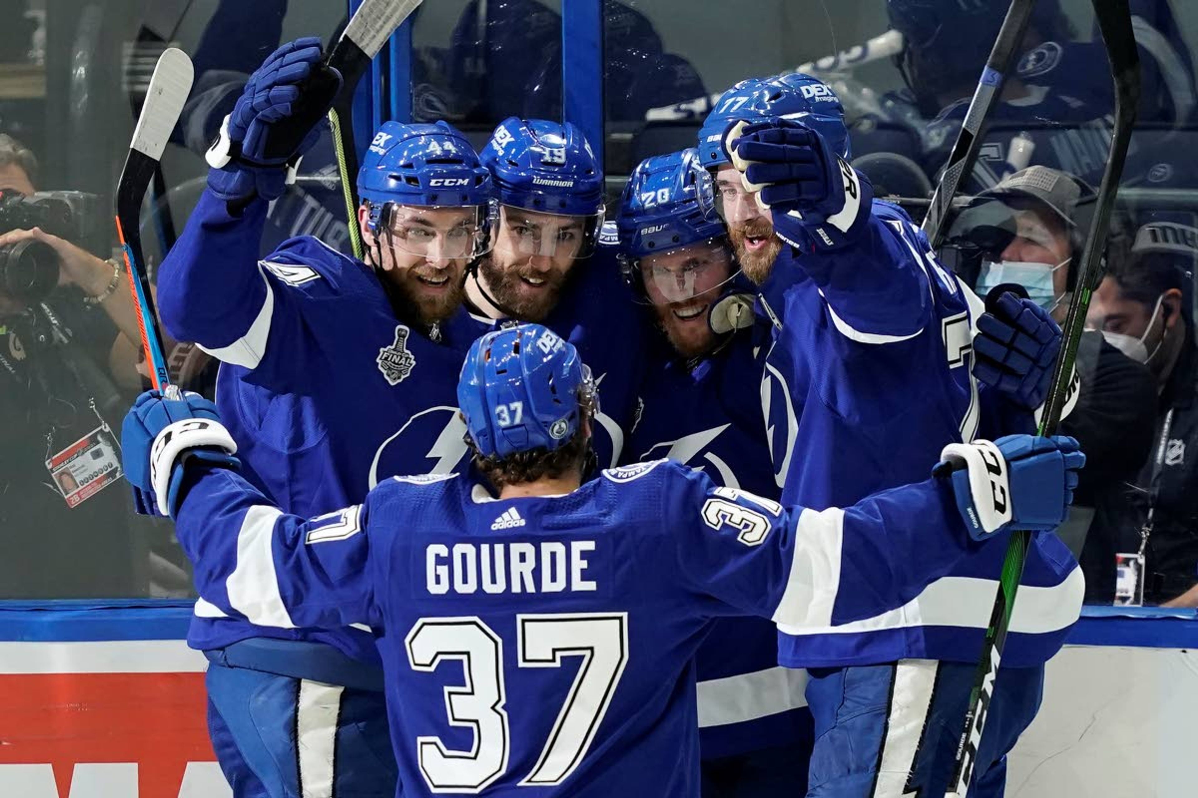 From left, Tampa Bay Lightning defenseman Jan Rutta, right wing Barclay Goodrow, center Blake Coleman and defenseman Victor Hedman wait to congratulate center Yanni Gourde (37) after his goal during the second period in Game 1 of the NHL hockey Stanley Cup finals against the Montreal Canadiens, Monday, June 28, 2021, in Tampa, Fla. (AP Photo/Gerry Broome)