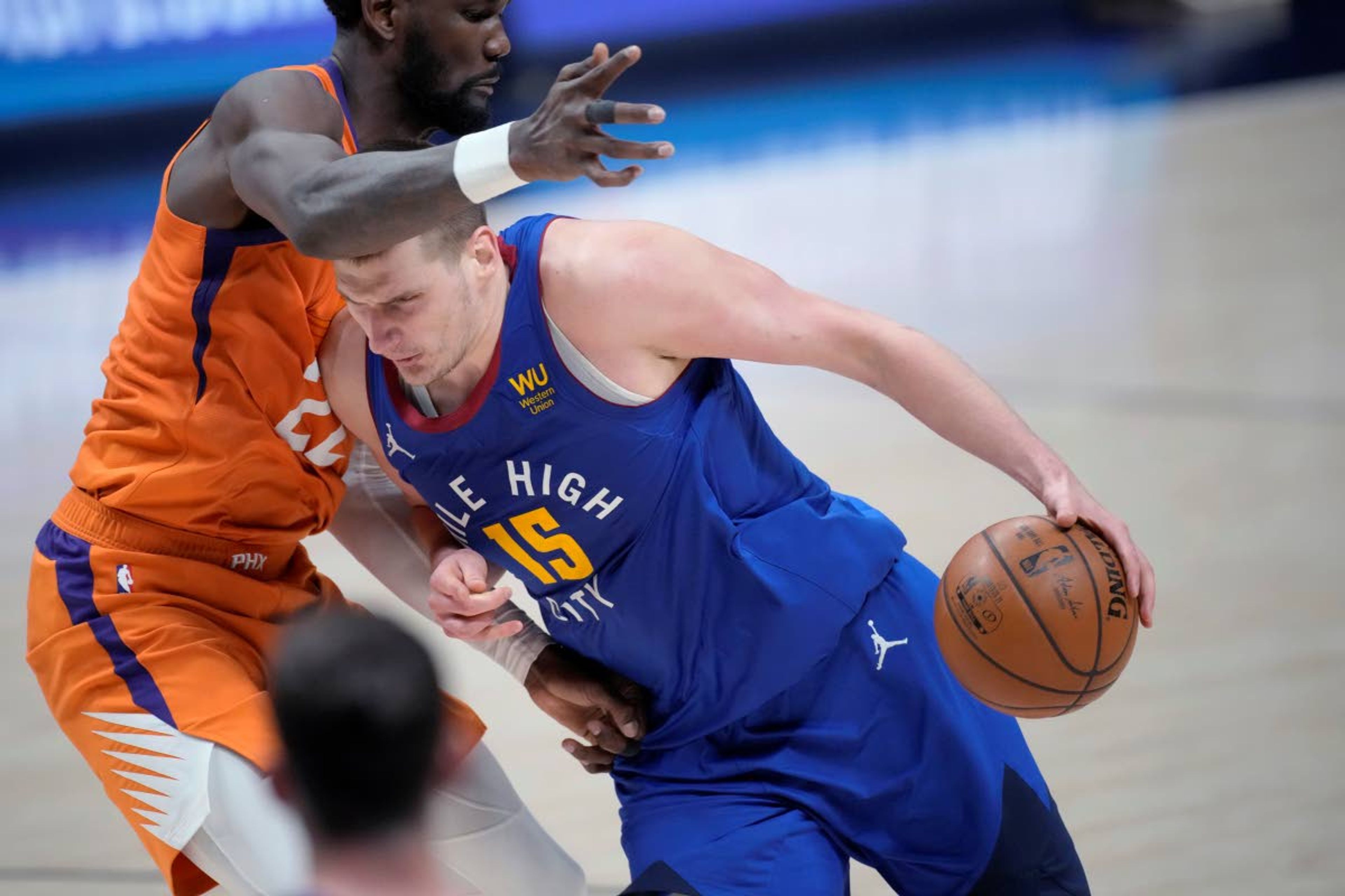 Denver Nuggets center Nikola Jokic drives as Phoenix Suns center Deandre Ayton defends during the second half of Game 3 of an NBA second-round playoff series Friday, June 11, 2021, in Denver. Phoenix won 116-102. (AP Photo/David Zalubowski)