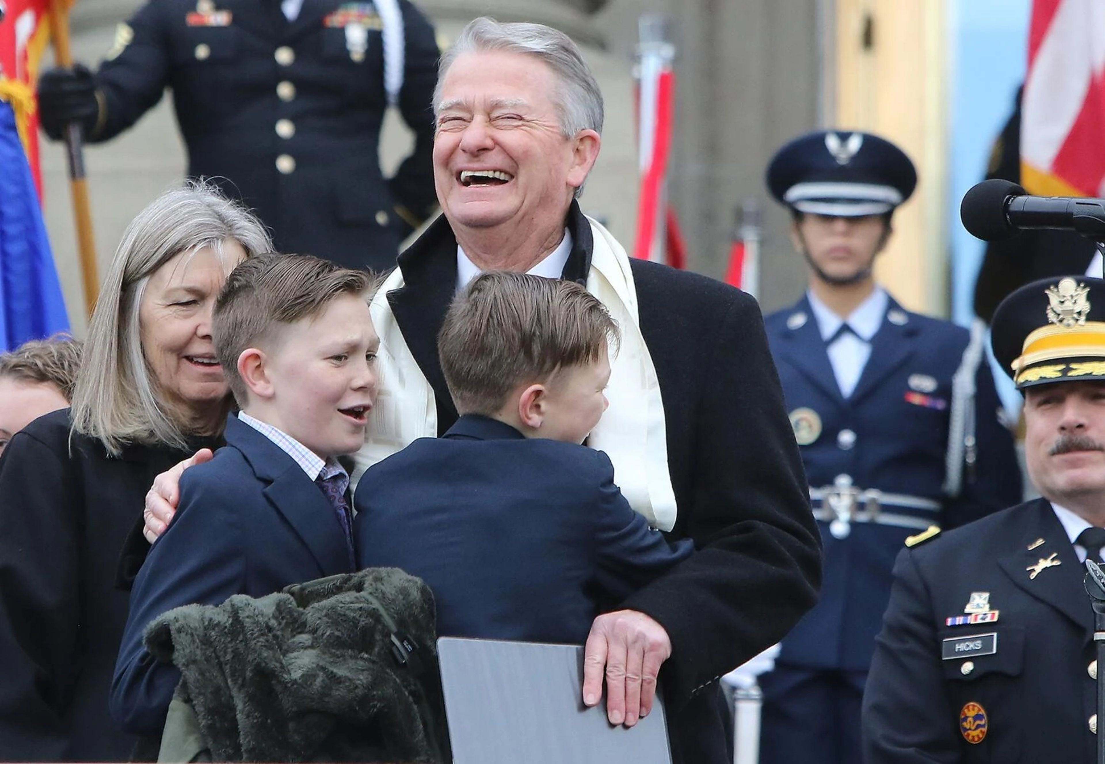 Gov. Brad Little react to a hug from his grandsons after delivering his inaugural address during a ceremony in front of the Idaho State Capitol on Friday.