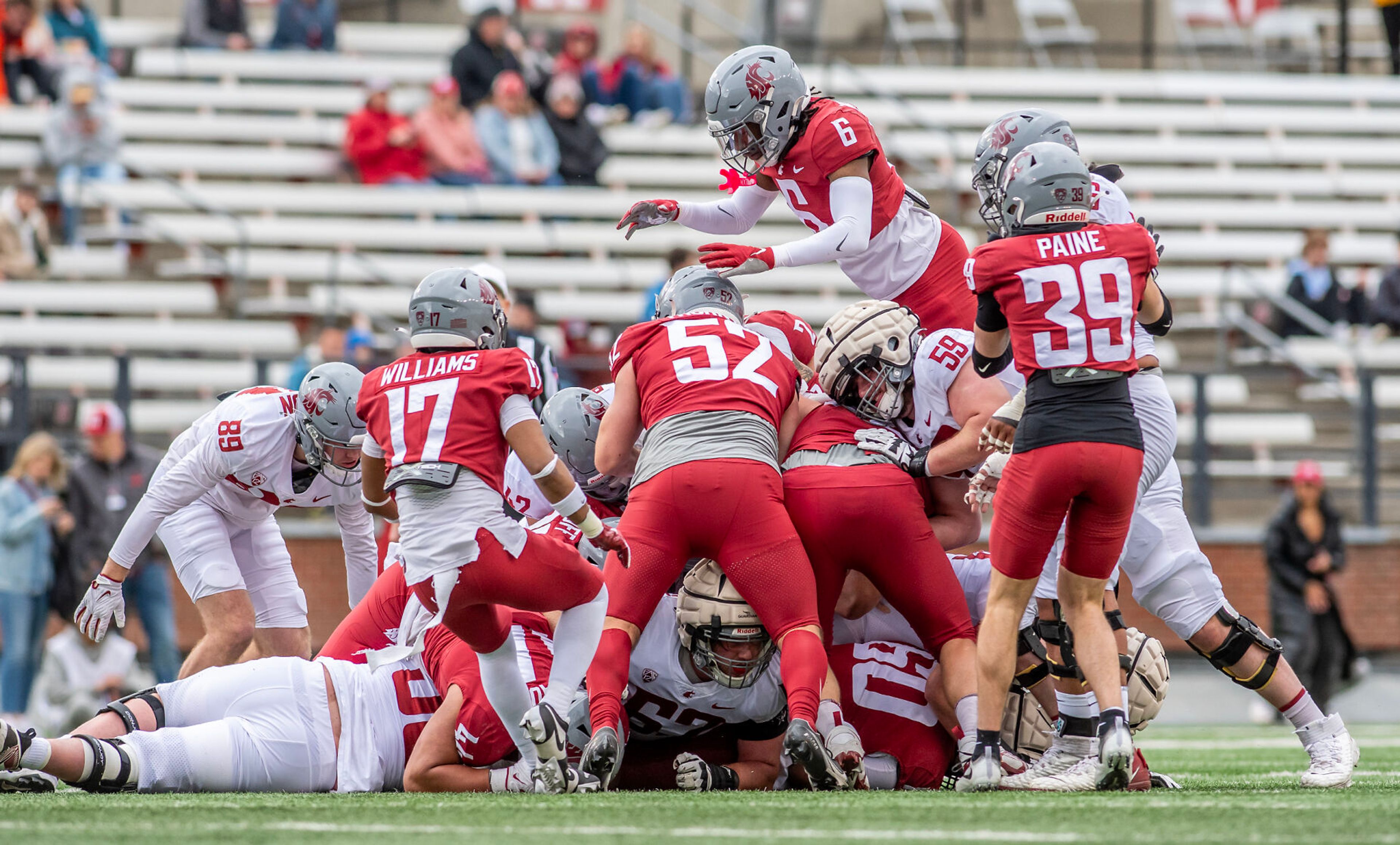 Crimson defensive back Adrian Wilson (6) leaps onto the pile in a quarter of the Crimson and Gray Game at Washington State University in Pullman.