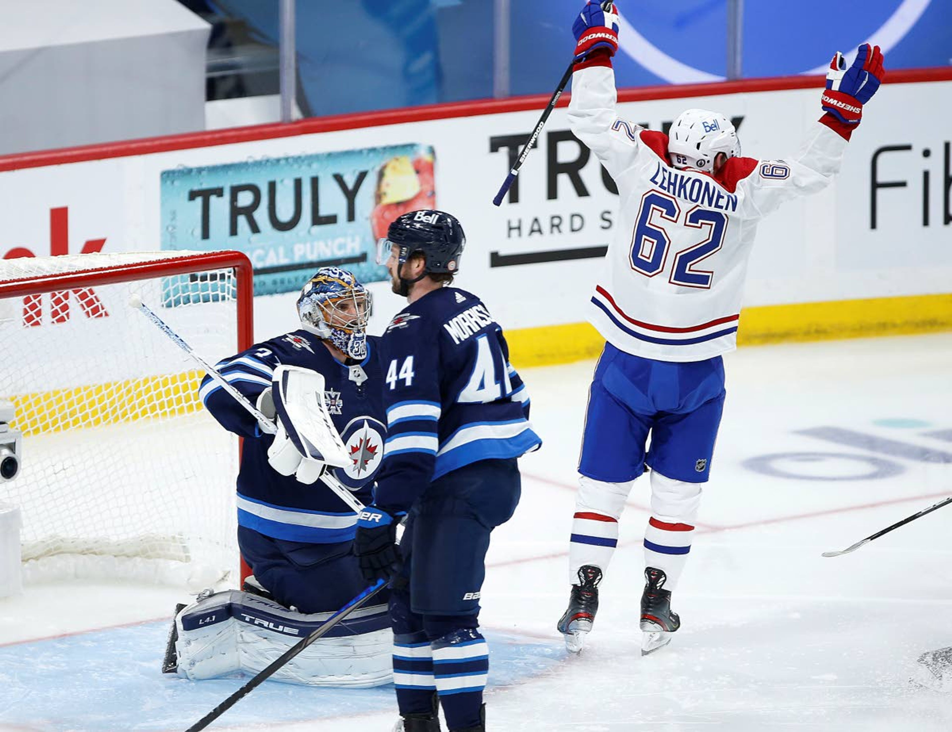 Montreal Canadiens' Artturi Lehkonen (62) celebrates a goal by Tyler Toffoli against Winnipeg Jets goaltender Connor Hellebuyck (37) during the second period of Game 2 of an NHL hockey Stanley Cup second-round playoff series Friday, June 4, 2021, in Winnipeg, Manitoba. (John Woods/The Canadian Press via AP)