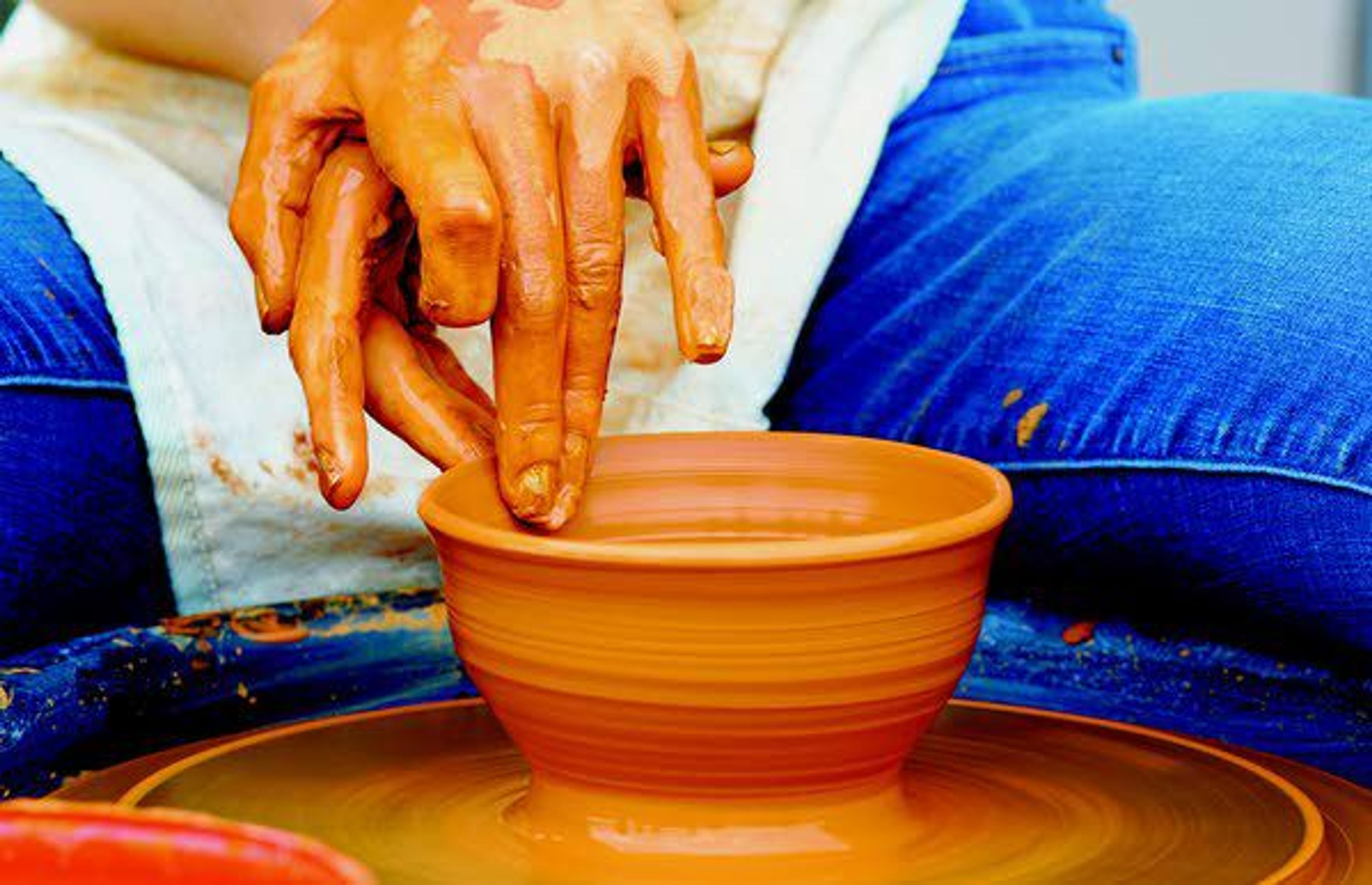 Haile Hunshaker makes a pot Saturday evening at the Dahmen Barn in Uniontown during a fundraiser for a new kiln shed.