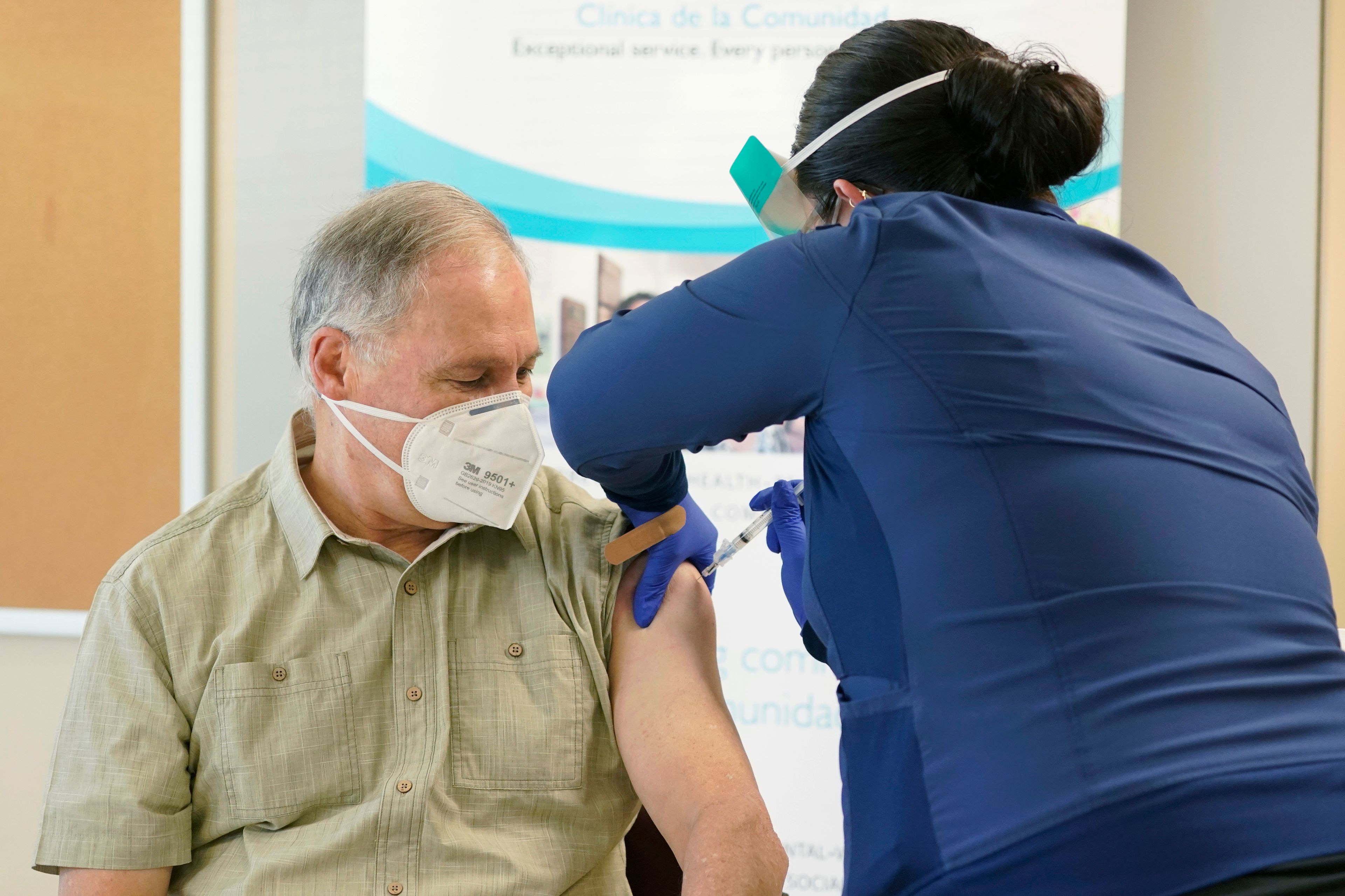 FILE - Washington Gov. Jay Inslee, left, gets the first shot of the Moderna COVID-19 vaccine, on Jan. 22, 2021, from Elizabeth Smalley, right, a medical assistant at a Sea Mar Community Health Center in Olympia, Wash. Gov. Inslee has tested positive for COVID-19, his office said Wednesday, May 25, 2022, the same day state health officials urged people to wear face mask indoors as case counts steadily rise. (AP Photo/Ted S. Warren, File)