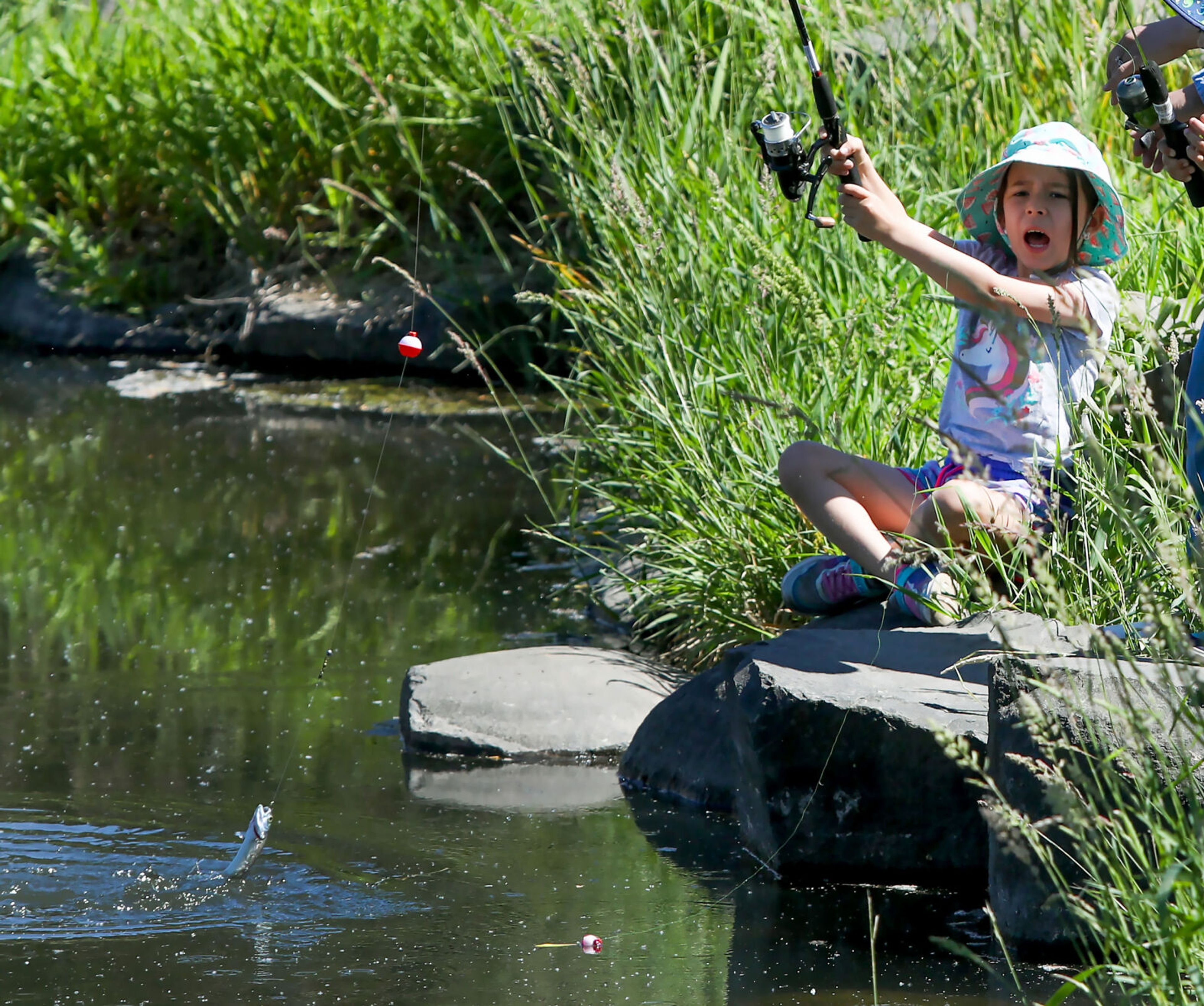 Nora O’Callaghan, 7, shouts with excitement while reeling in her first-ever fish at Kiwanis Park Pond during Idaho's Free Fishing Day on Saturday in Lewiston.