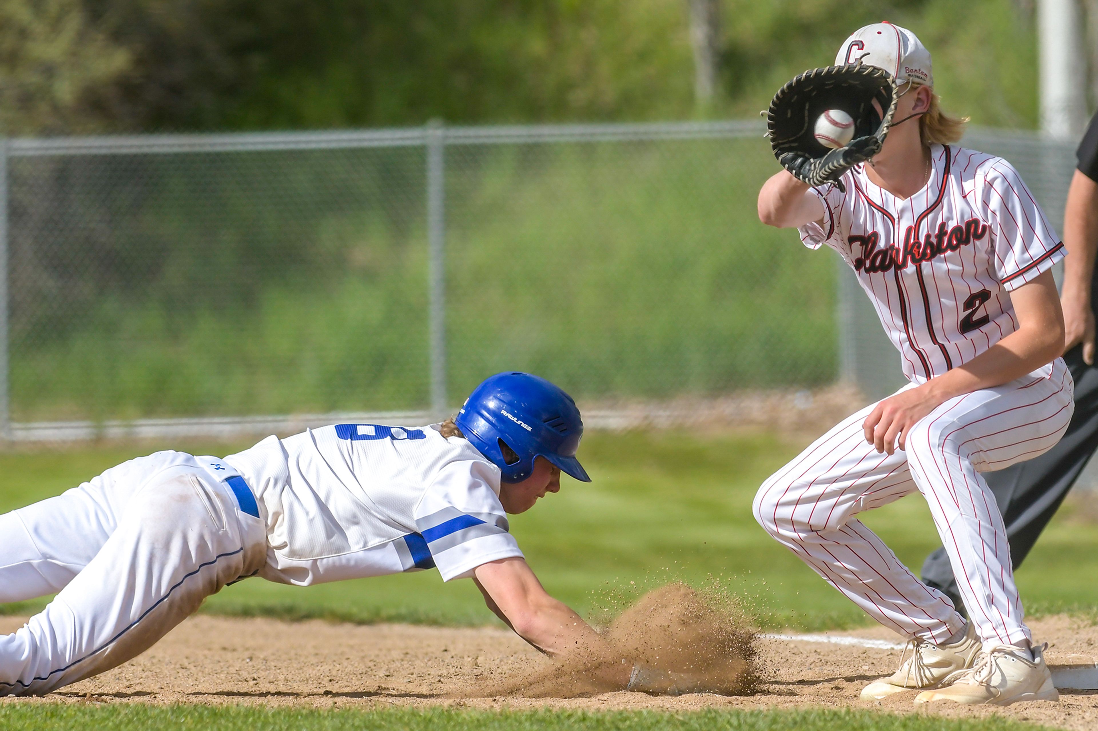 Clarkston first baseman Jacob Stewart catches a ball thrown back to first as Pullman’s Joey Hecker jumps back to first during a semifinal game of the district tournament Thursday in Pullman.