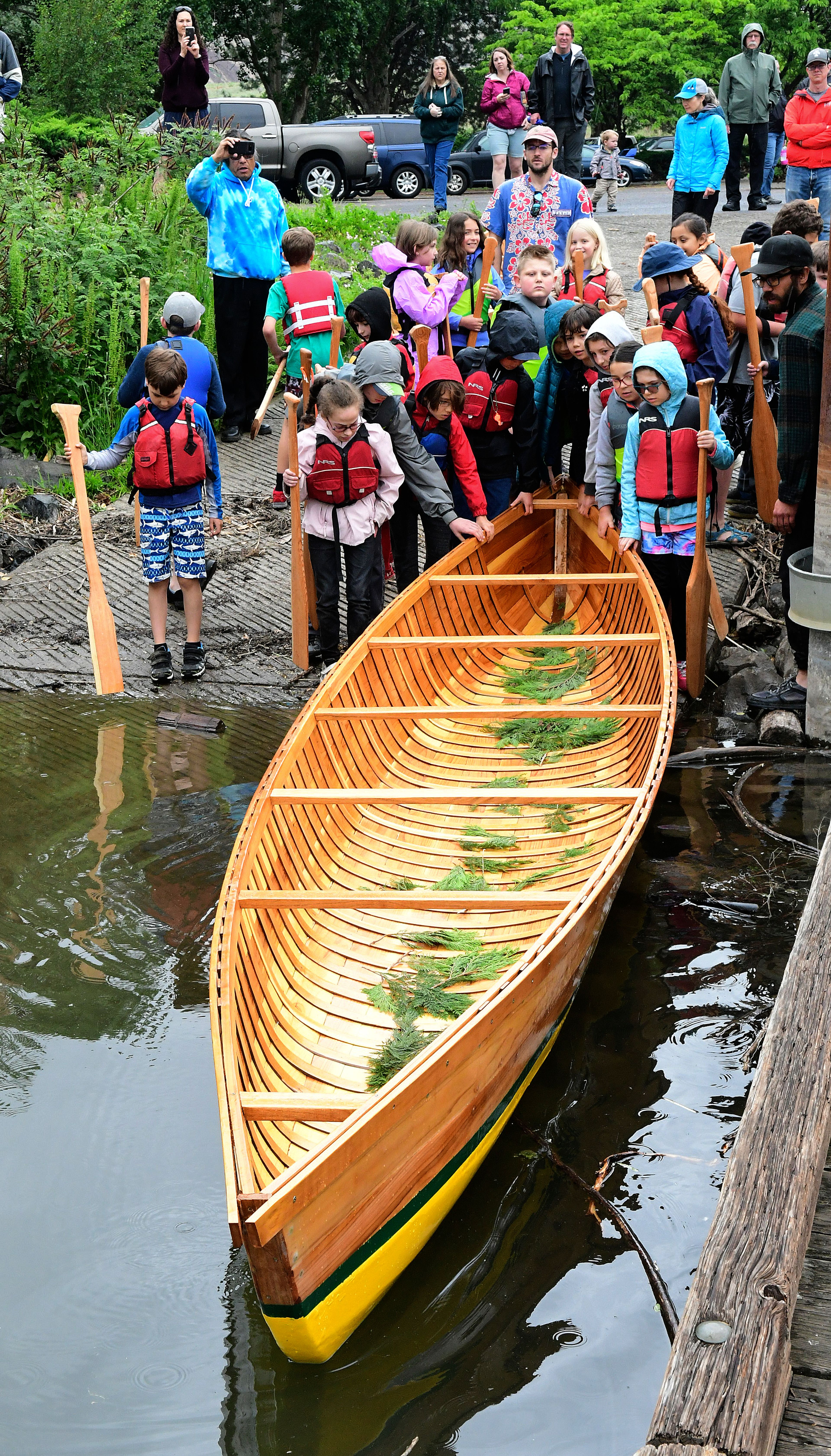 With guidance from Xander Demetrious and Adam Wicks-Arshack, Renee Hill’s fourth grade students built the 22 foot cedar plank canoe at Palouse Prairie Charter School at Moscow in their spare time over two months, while studying canoes and American Indian culture. With the help of Nez Perce Tribal members, the canoe, named The Chinook, was blessed Friday and then carried by all the students (“It’s heavy!”), and launched in the Snake River. The handmade boat was paddled around Silcott Island in a light rain. The canoe will be donated to the Nimiipuu Protecting The Environment group of the Nez Perce Tribe for teaching and regional demonstrations.