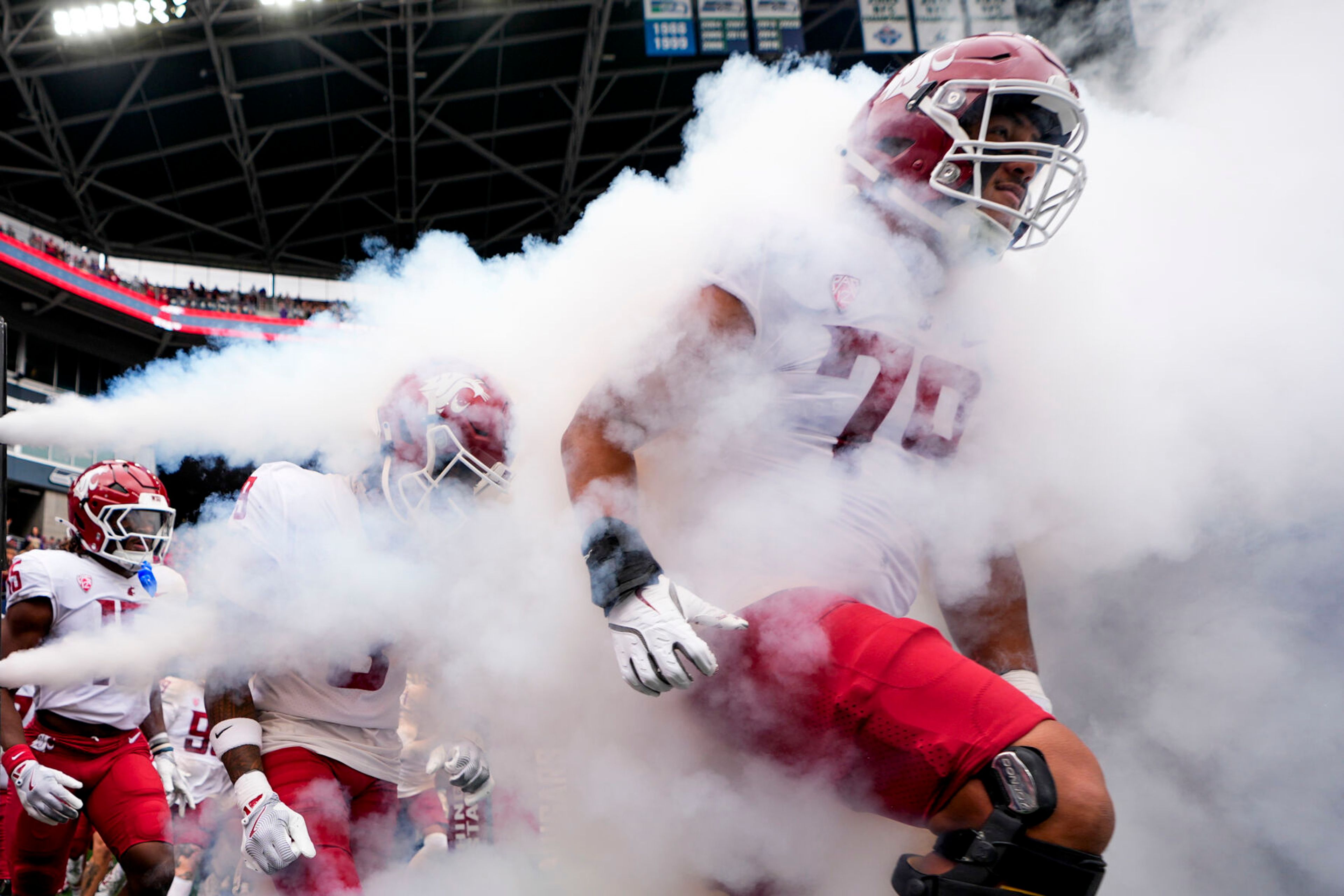 Washington State players run out onto the field before an NCAA college football game against Washington, Saturday, Sept. 14, 2024, in Seattle. (AP Photo/Lindsey Wasson)