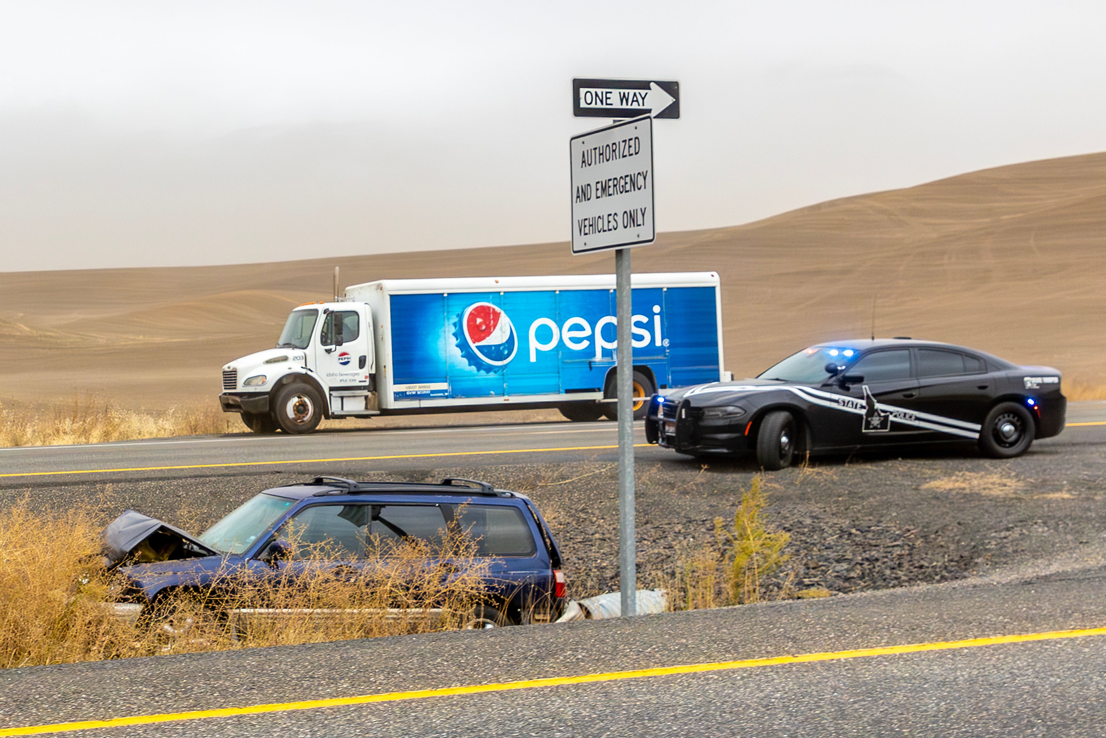 Police respond to a multiple wrecked cars in the southbound lane of U.S. Highway 95 as heavy wind blows dust across the region Friday.