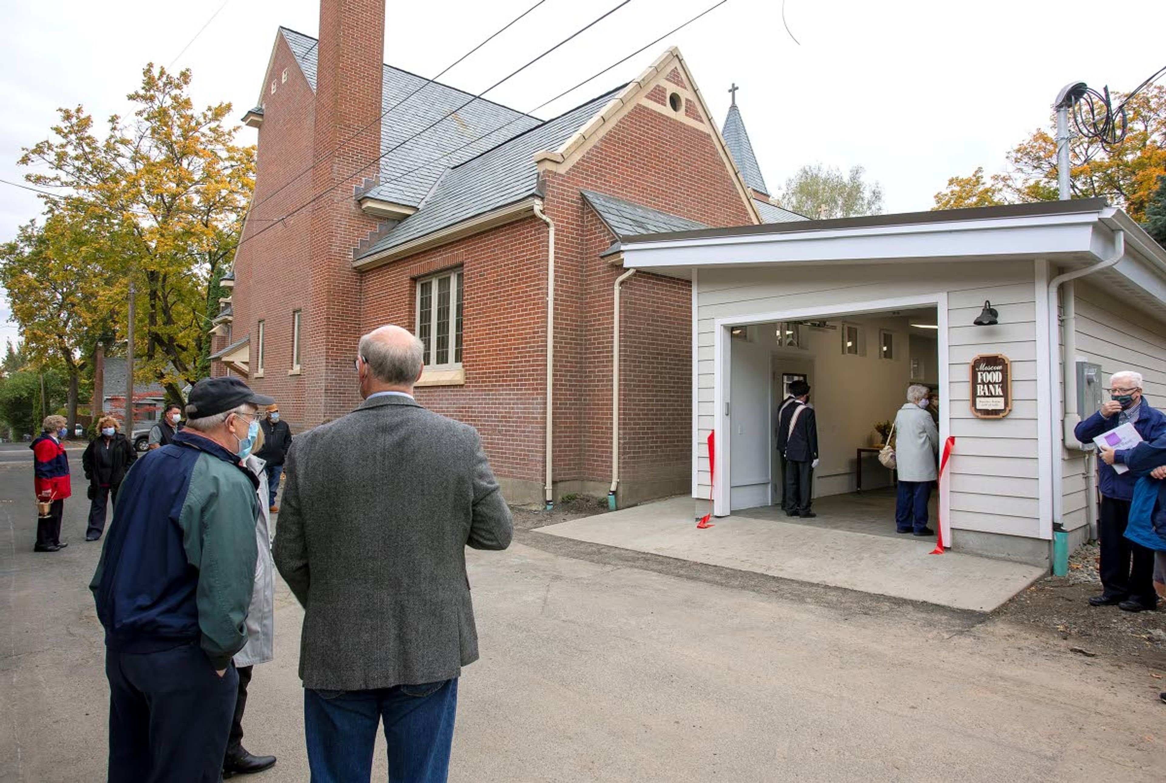 People gather outside the new 740-square-foot distribution and storage building on Saturday outside the Moscow Food Bank. The food bank is a parish ministry of St. Mary's Church.