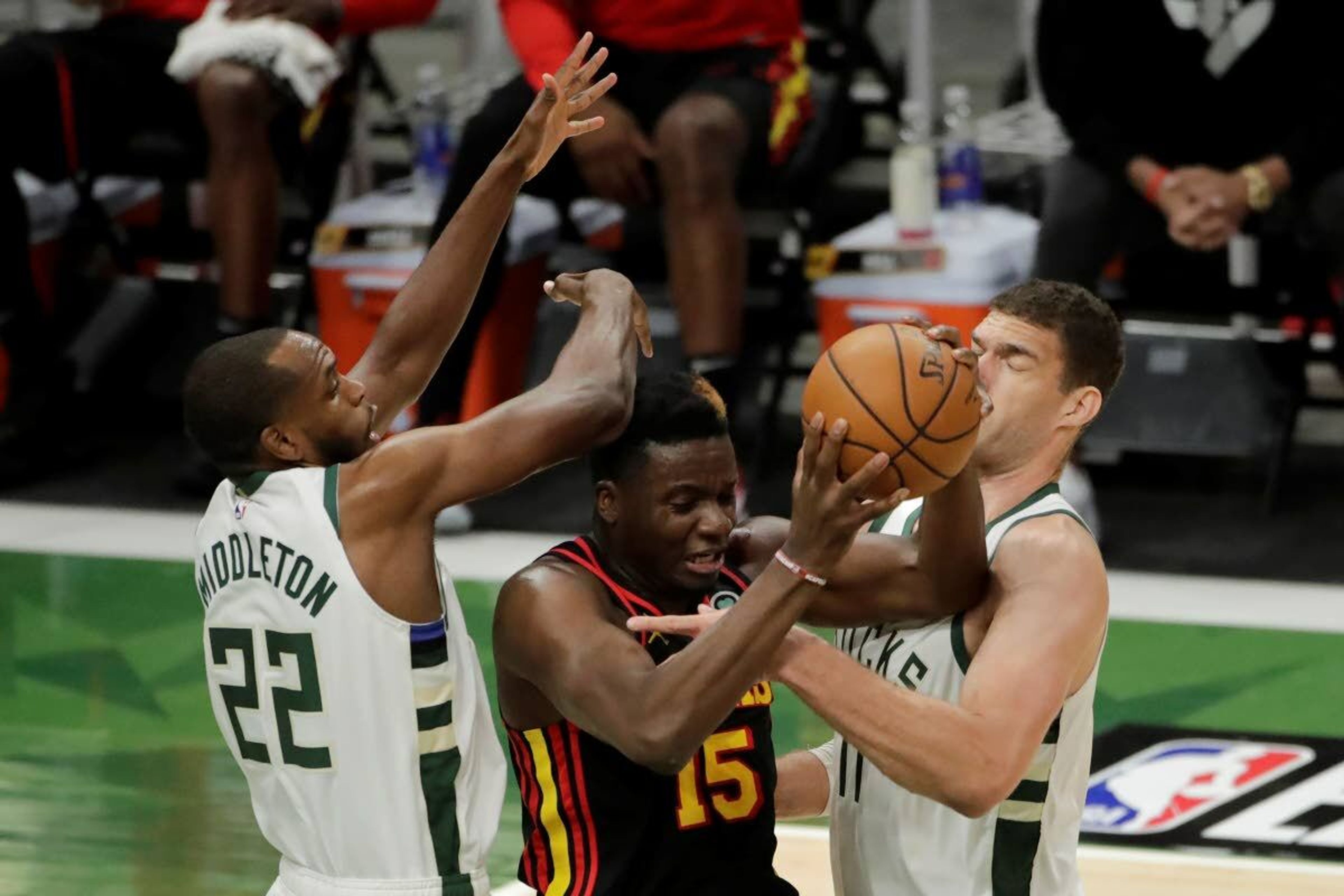 Atlanta Hawks' Clint Capela, center, attempts to control a rebound between Milwaukee Bucks' Khris Middleton, left, and Brook Lopez, right, during the first half of Game 5 of the NBA Eastern Conference Finals Thursday, July 1, 2021, in Milwaukee. (AP Photo/Aaron Gash)