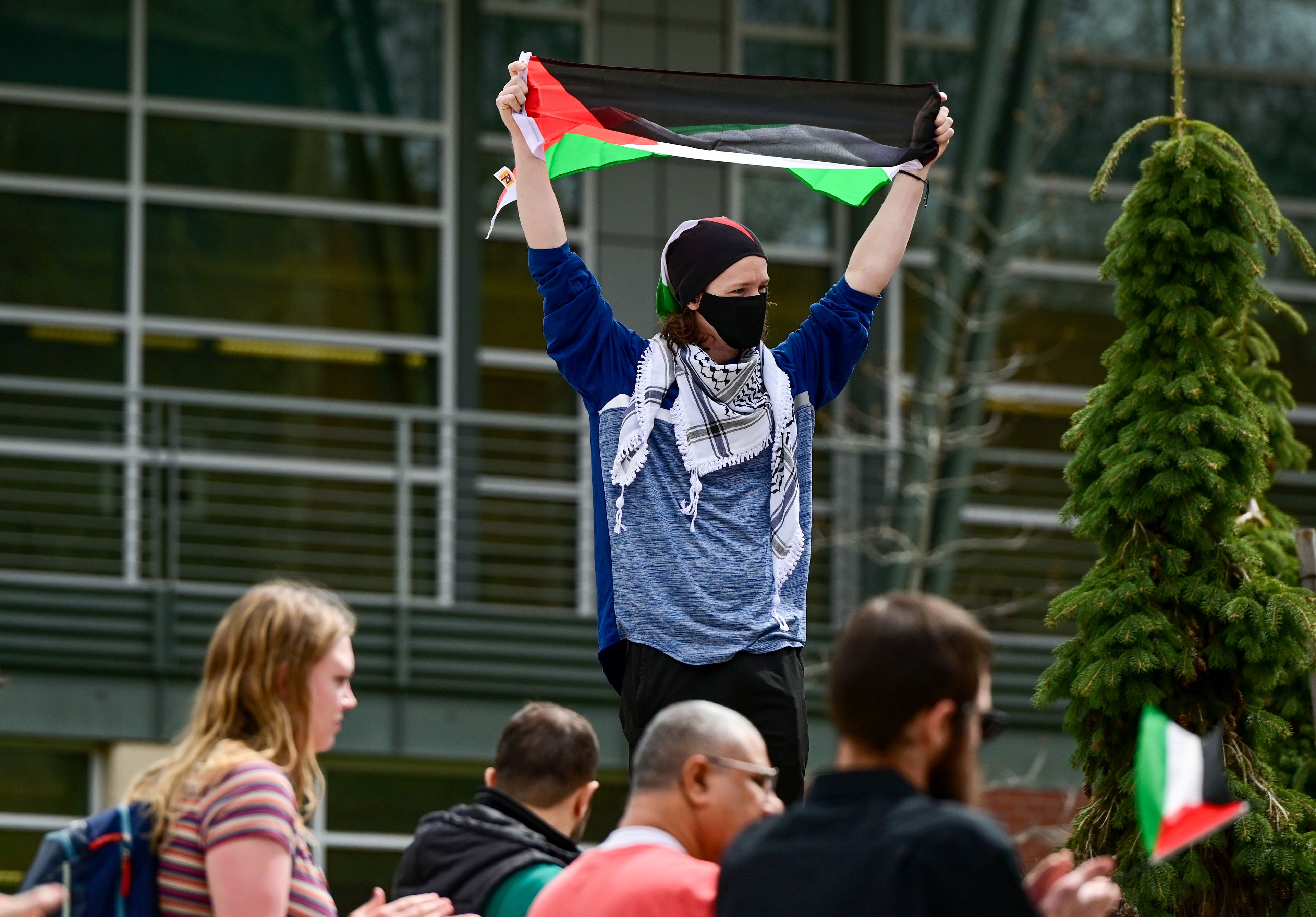 Josiah Andrews, a Moscow resident, raises a Palestinian flag while listening to speakers at a Palestine Week of Action demonstration outside of the University of Idaho Library in Moscow on Thursday.