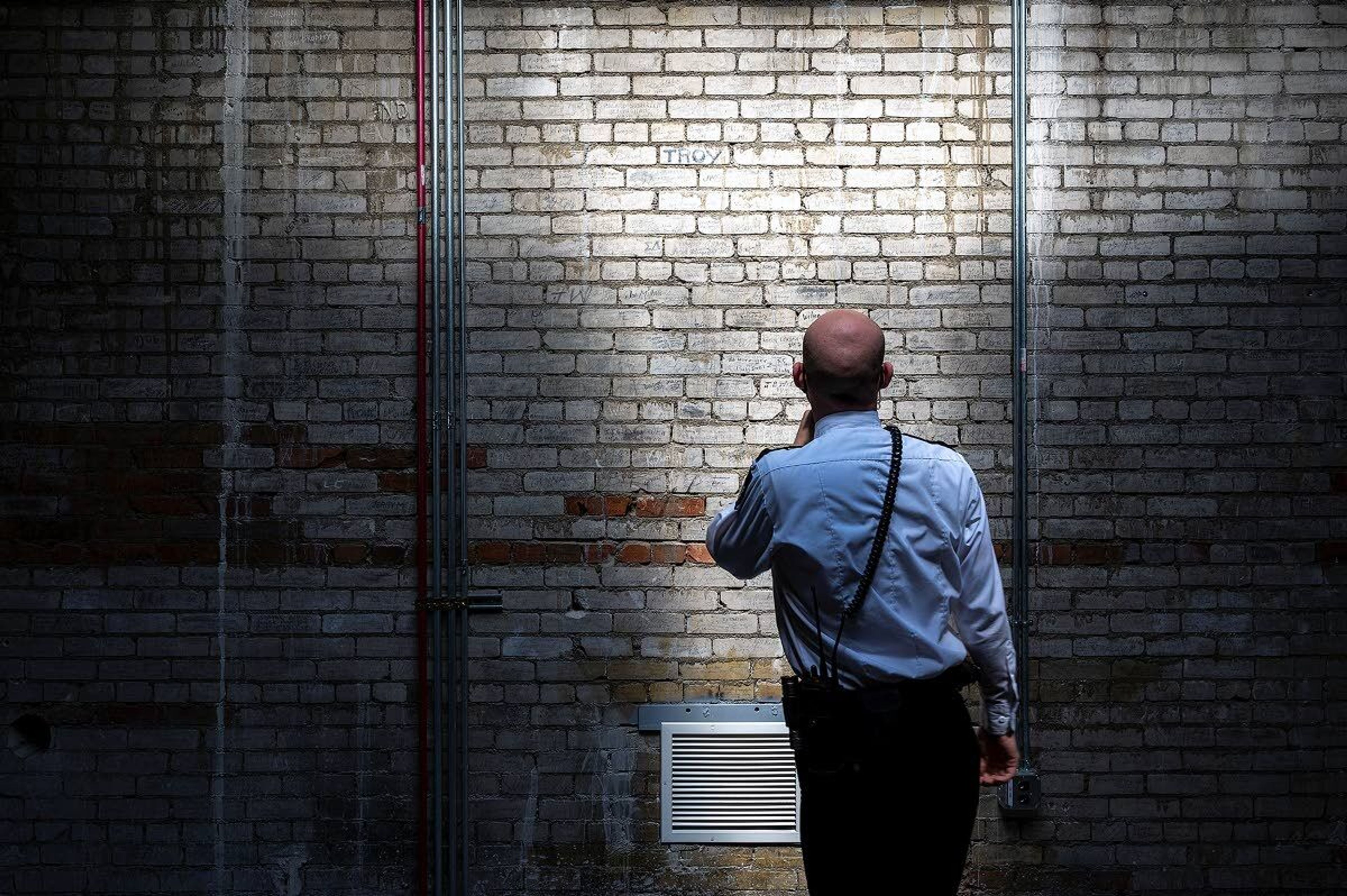 Security guard Russell Howe looks at the hundreds of bricks in a room at the top of the Capitol dome that have been signed by pages who worked in the Idaho Senate or the House of Representatives. Some of the names date back to the early 1920s.