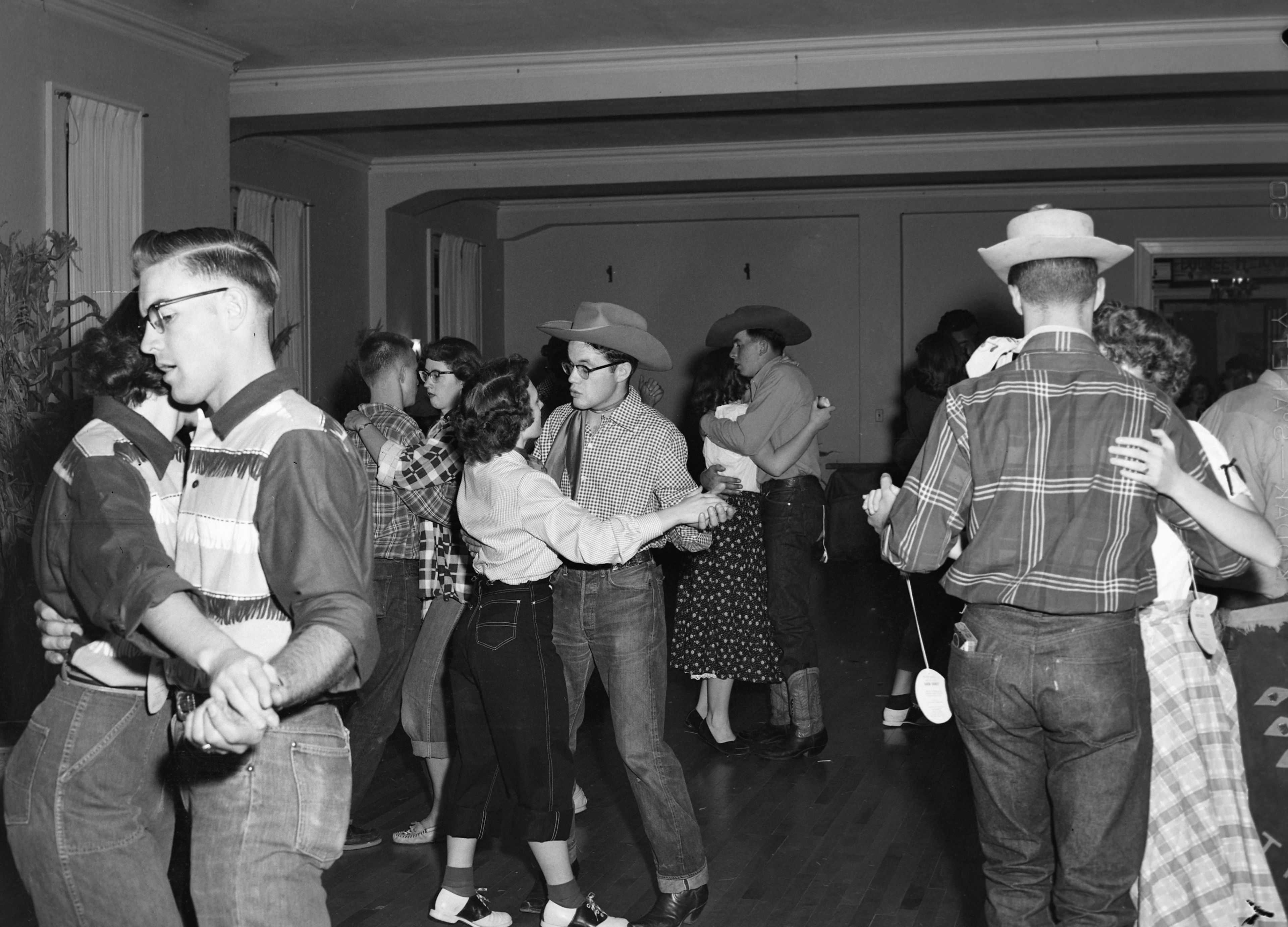 Couples partner up at a Western-themed dance circa 1948-56.