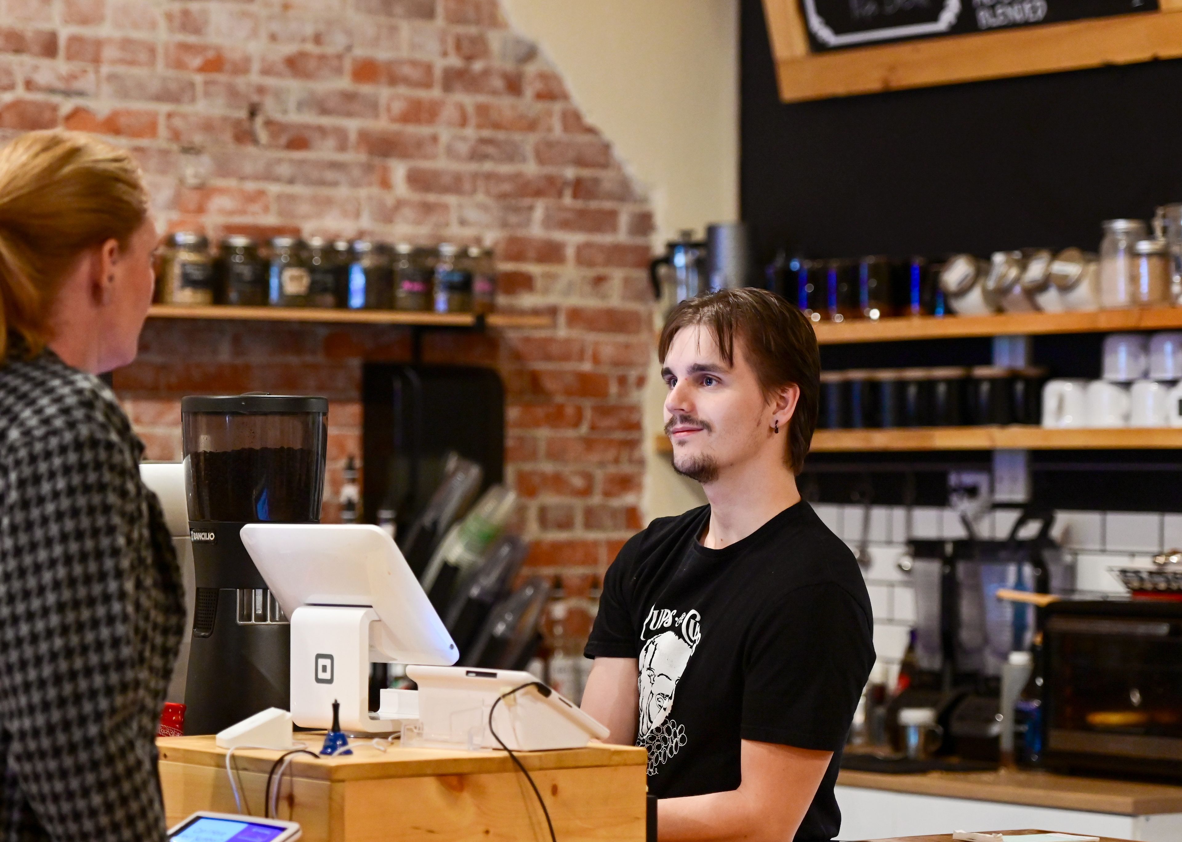 Quinn Madsen, right, a manager in training, takes orders behind the counter of Pups & Cups Cafe in downtown Pullman on Wednesday, Nov. 15.