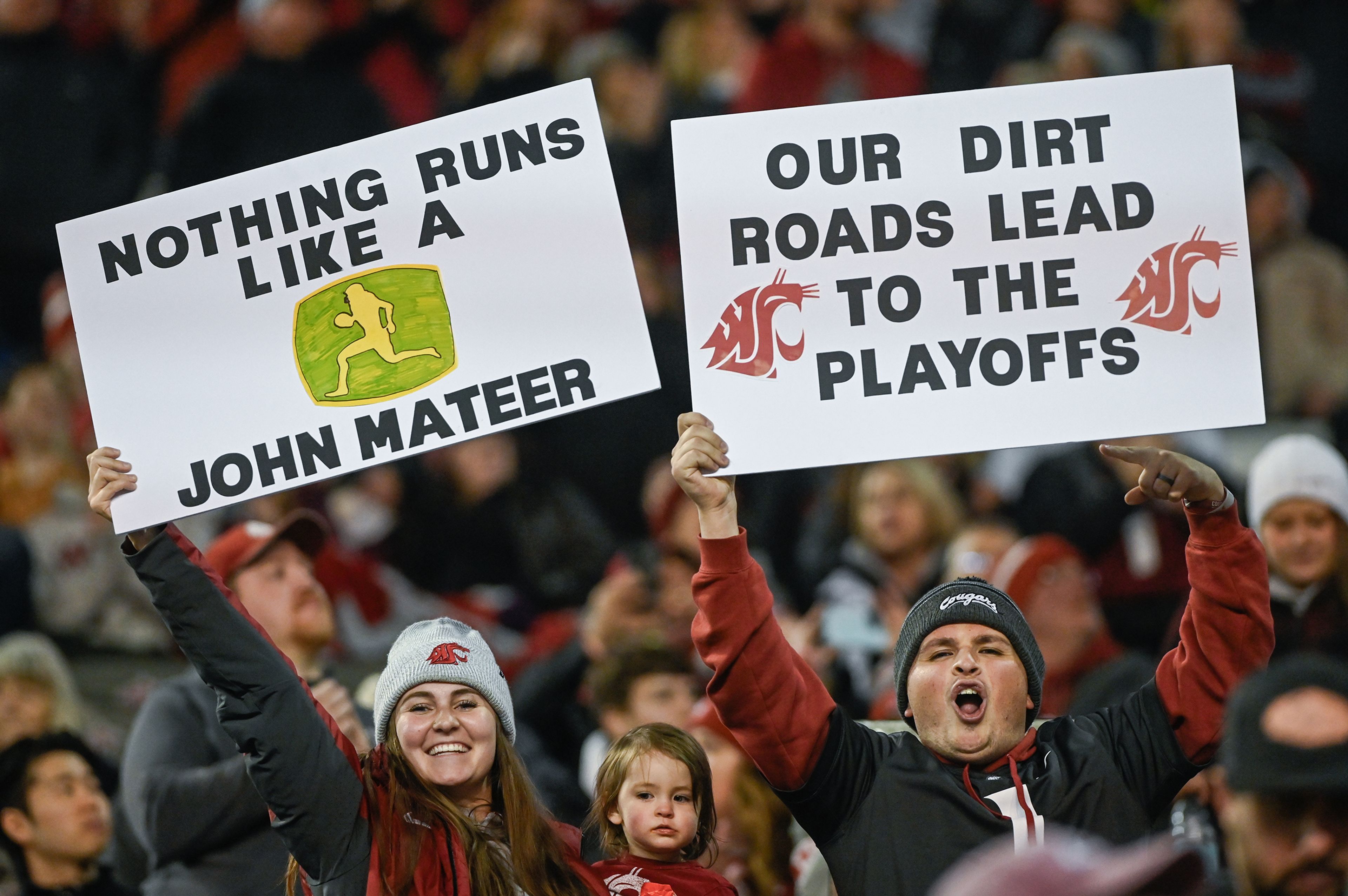 Washington State fans raise signs from the stands Saturday during a game against Utah State at Gesa Field in Pullman.