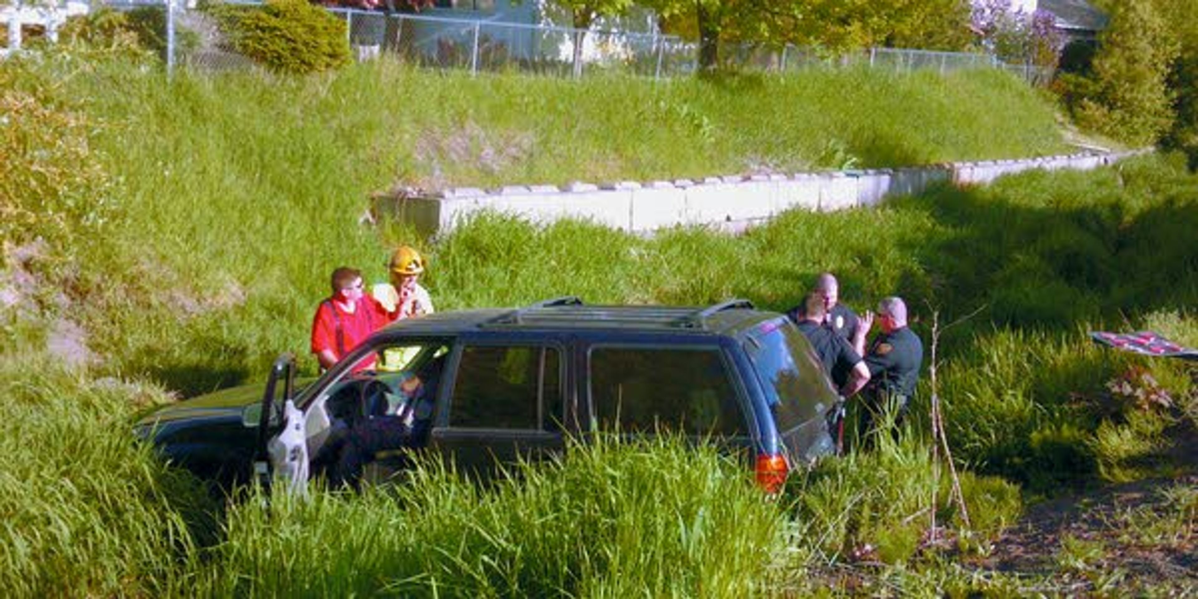 Members of the Moscow Volunteer Fire Department and Moscow Police Department inspect a vehicle that plunged into Paradise Creek on Monday while trying to elude police in Moscow.