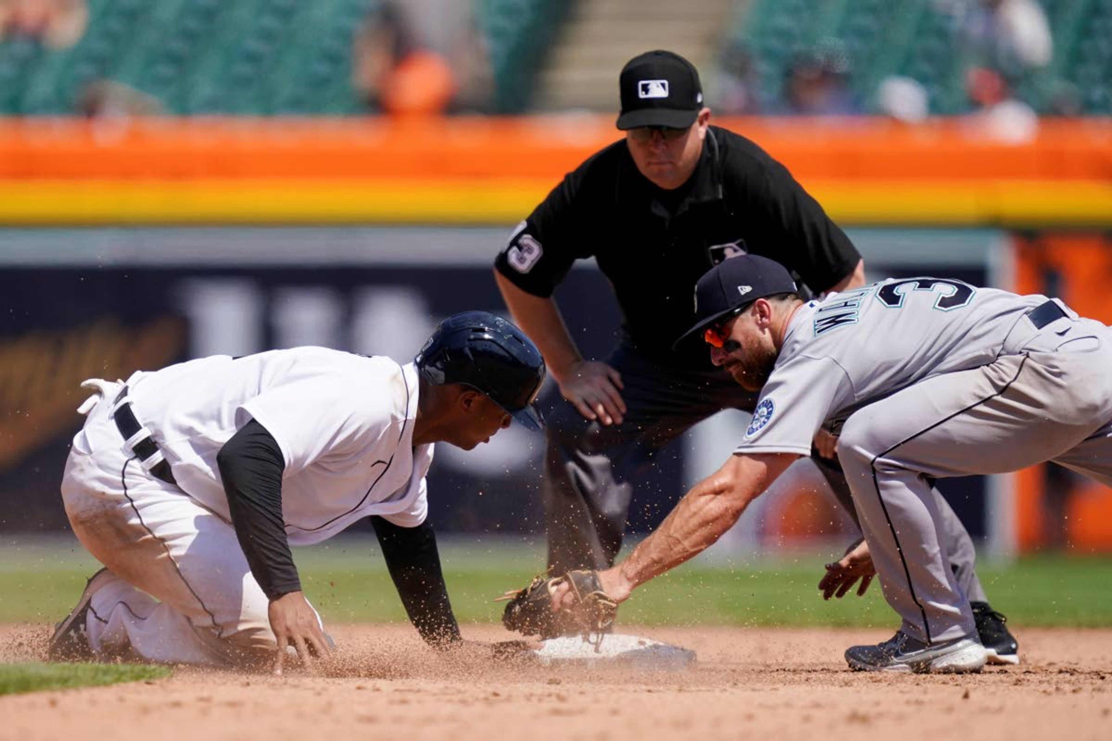 Detroit Tigers' Jonathan Schoop, left, safely beats the tag of Seattle Mariners second baseman Donovan Walton (31) as umpire Todd Tichenor looks on during the sixth inning of a baseball game, Thursday, June 10, 2021, in Detroit. (AP Photo/Carlos Osorio)