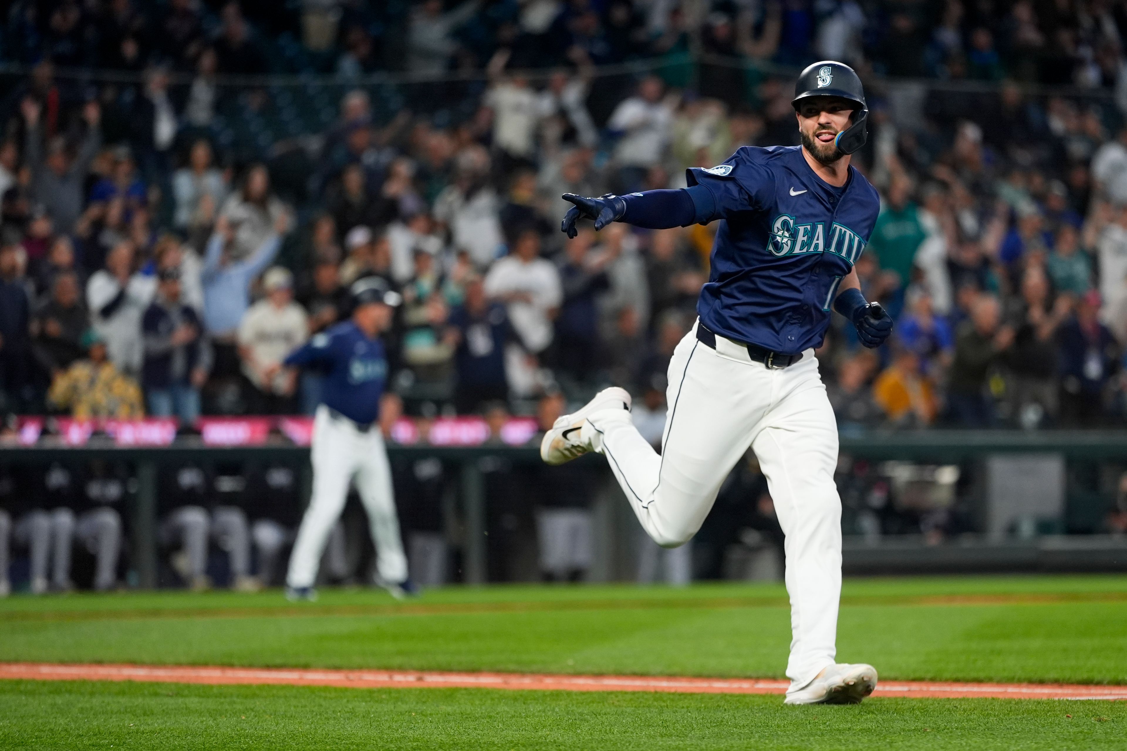 The Mariners’ Mitch Haniger points as he runs to first on a single that drove in the winning run against the White Sox during the 10th inning of a game Wednesday in Seattle.