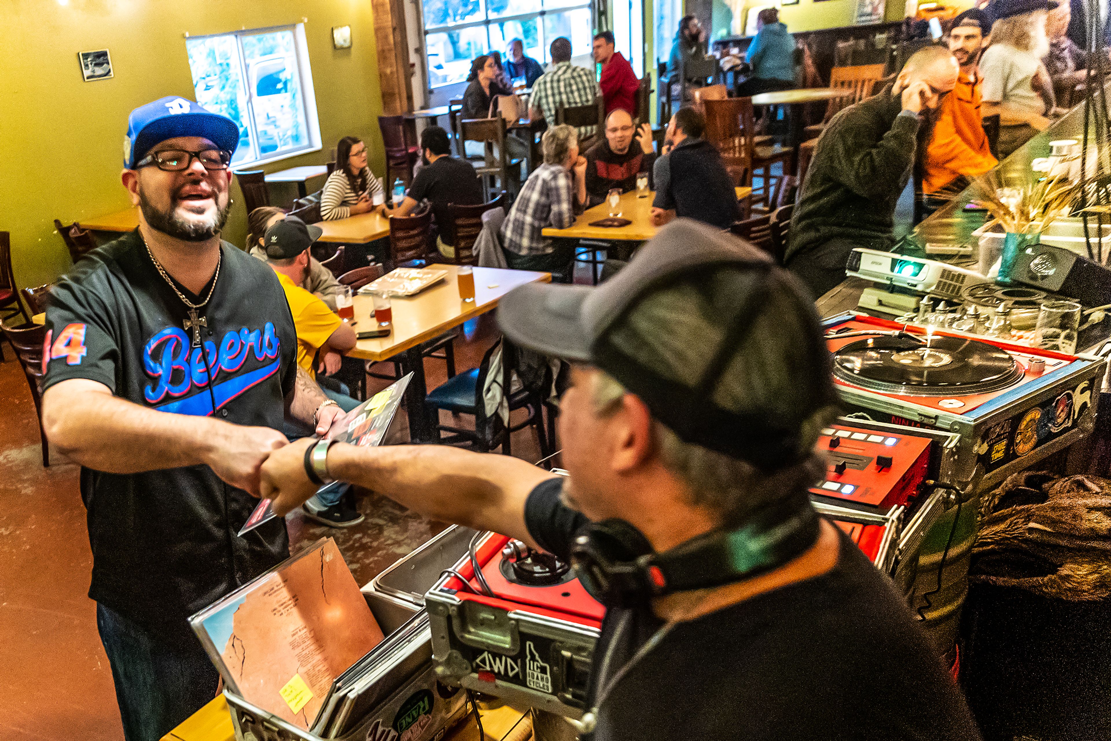 David Campillo gives Ryan Mohr, of Moscow, a fist bump during Bring Your Own Vinyl Night Wednesday at Moscow Brewing Company.