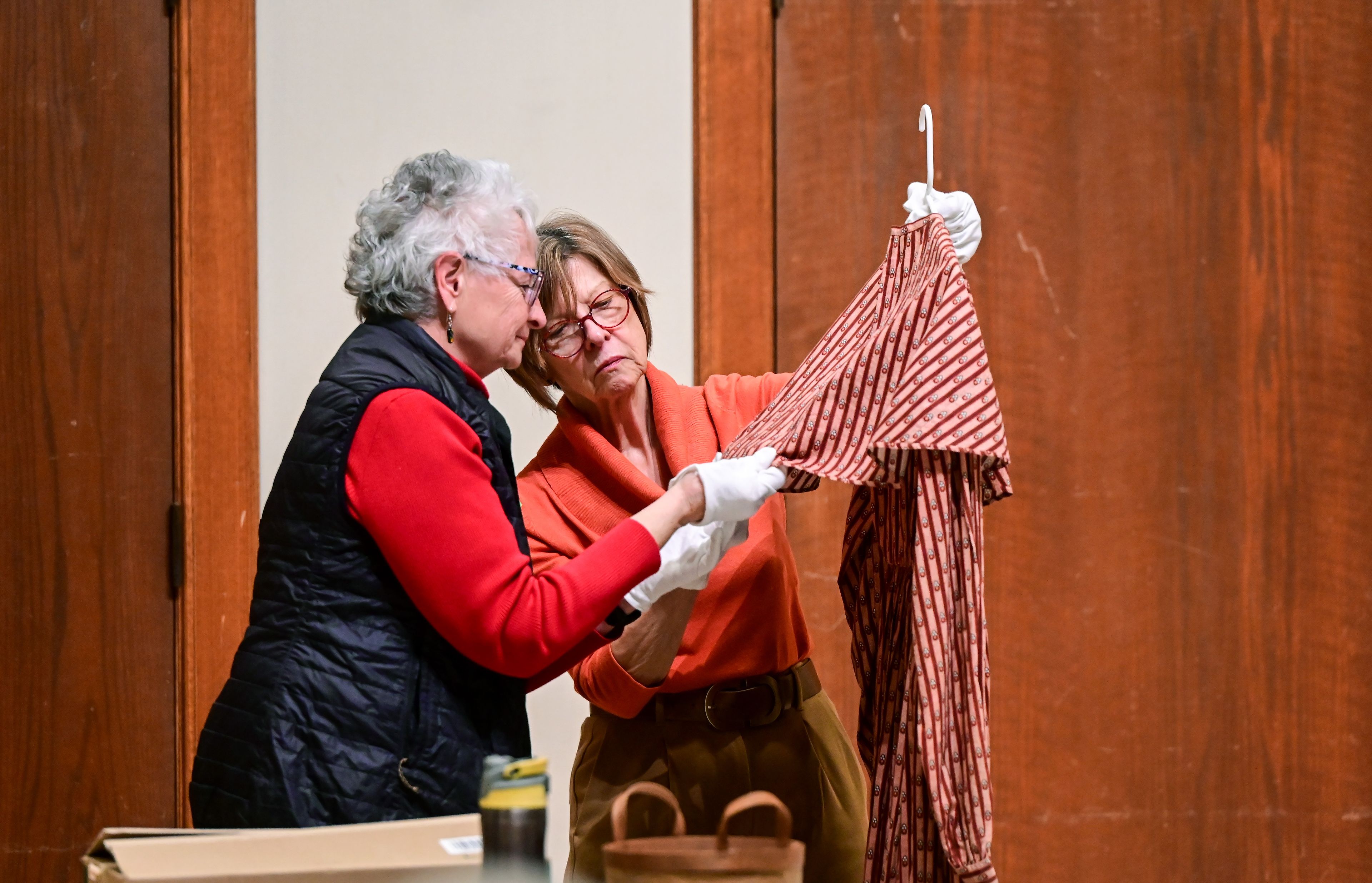 Celia Boland, left, takes a closer look at a dress from the Leila Old Historic Costume Collection with collection curator and University of Idaho professor Sonya Meyers during a Palouse Patchers meeting at the 1912 Center in Moscow on Tuesday.