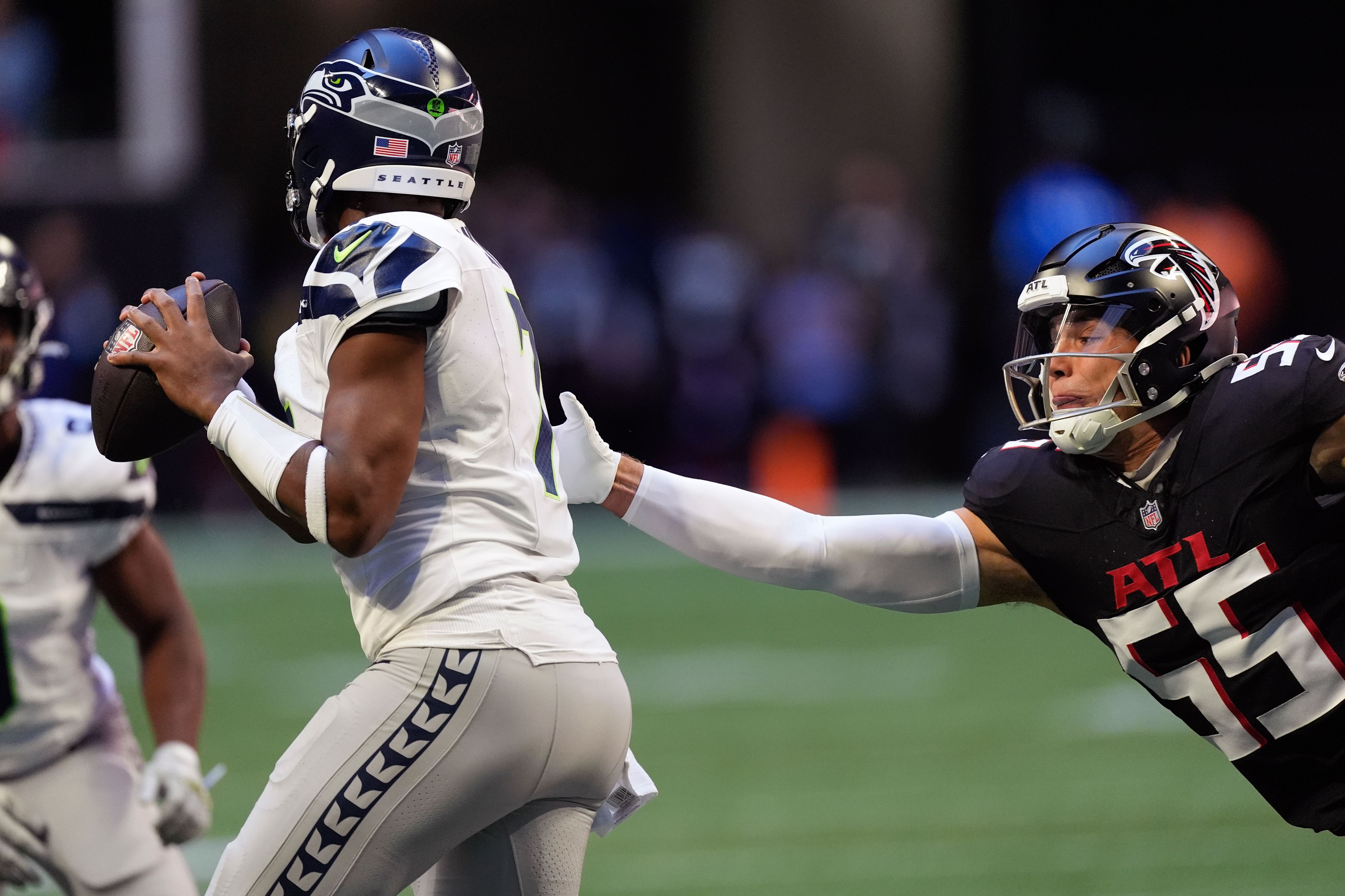 Seattle Seahawks quarterback Geno Smith (7) throws under pressure from Atlanta Falcons linebacker Kaden Elliss (55) during the first half of an NFL football game, Sunday, Oct. 20, 2024, in Atlanta. (AP Photo/ Mike Stewart )