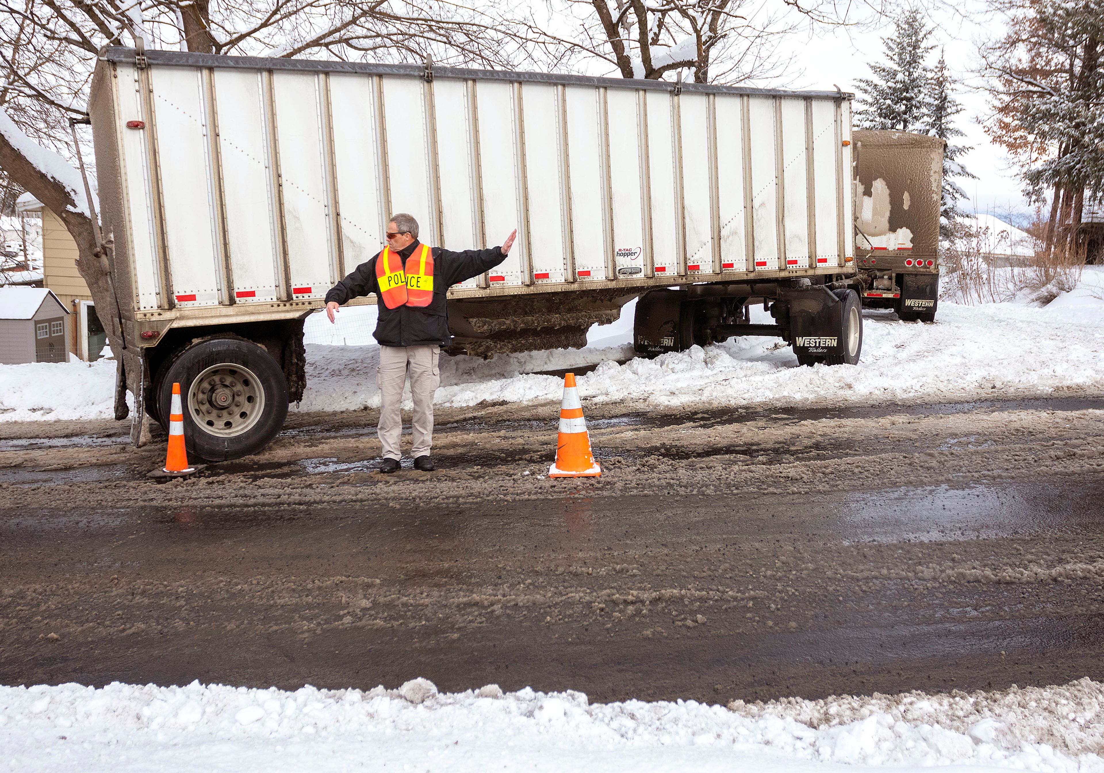 Code Enforcement Officer Alan Johnson directs traffic around a semitractor-trailer that got stuck on Thursday at the intersection of East D Street and North Van Buren Street in Moscow.