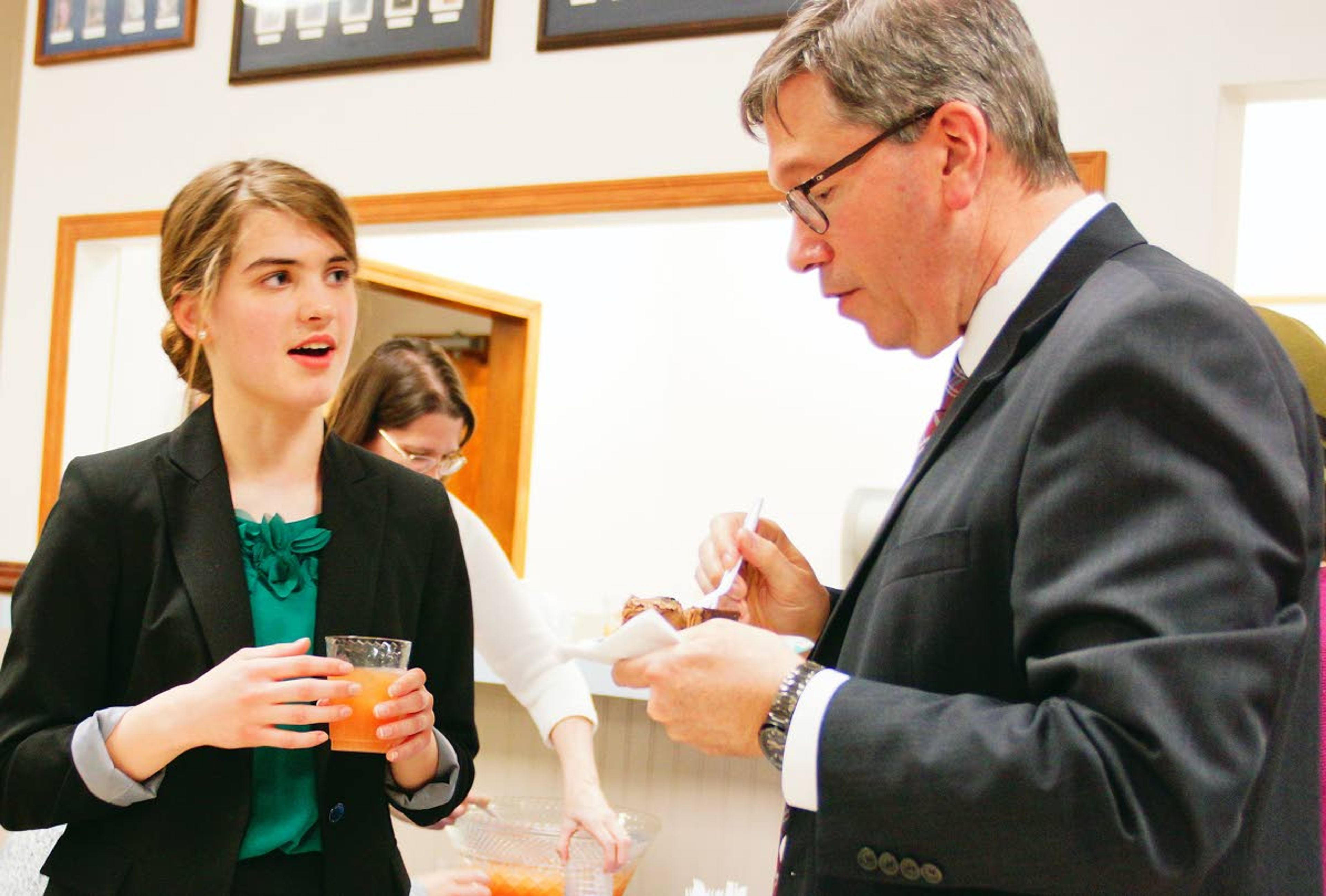 Laina Wyrick, a member of Logos' state title-winning mock trial team talks with Idaho Supreme Court Justice Gregory Moeller during an awards ceremony last week in Moscow.