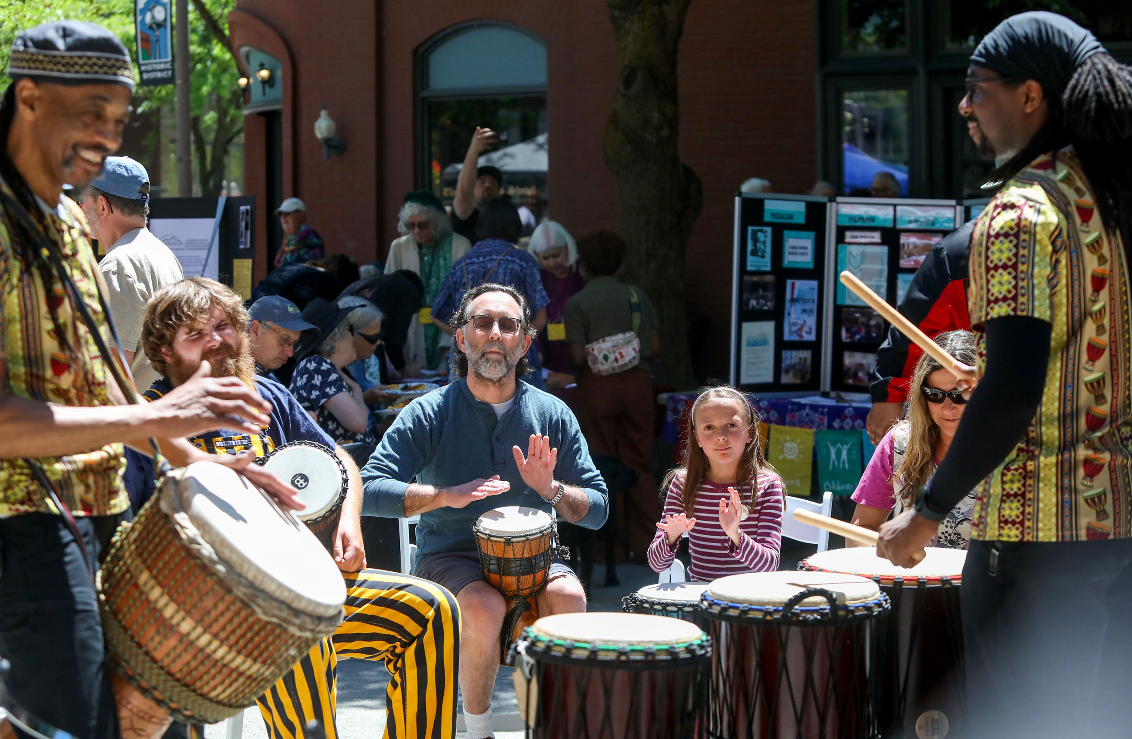 Community members take part in a drum circle led by Darryl Singleton, left, a jazz faculty member at the Washington State University School of Music, and son, Samuel Singleton, right, including Scott Milner, center, of Moscow, at a Juneteenth celebration in Friendship Square on Wednesday in Moscow.