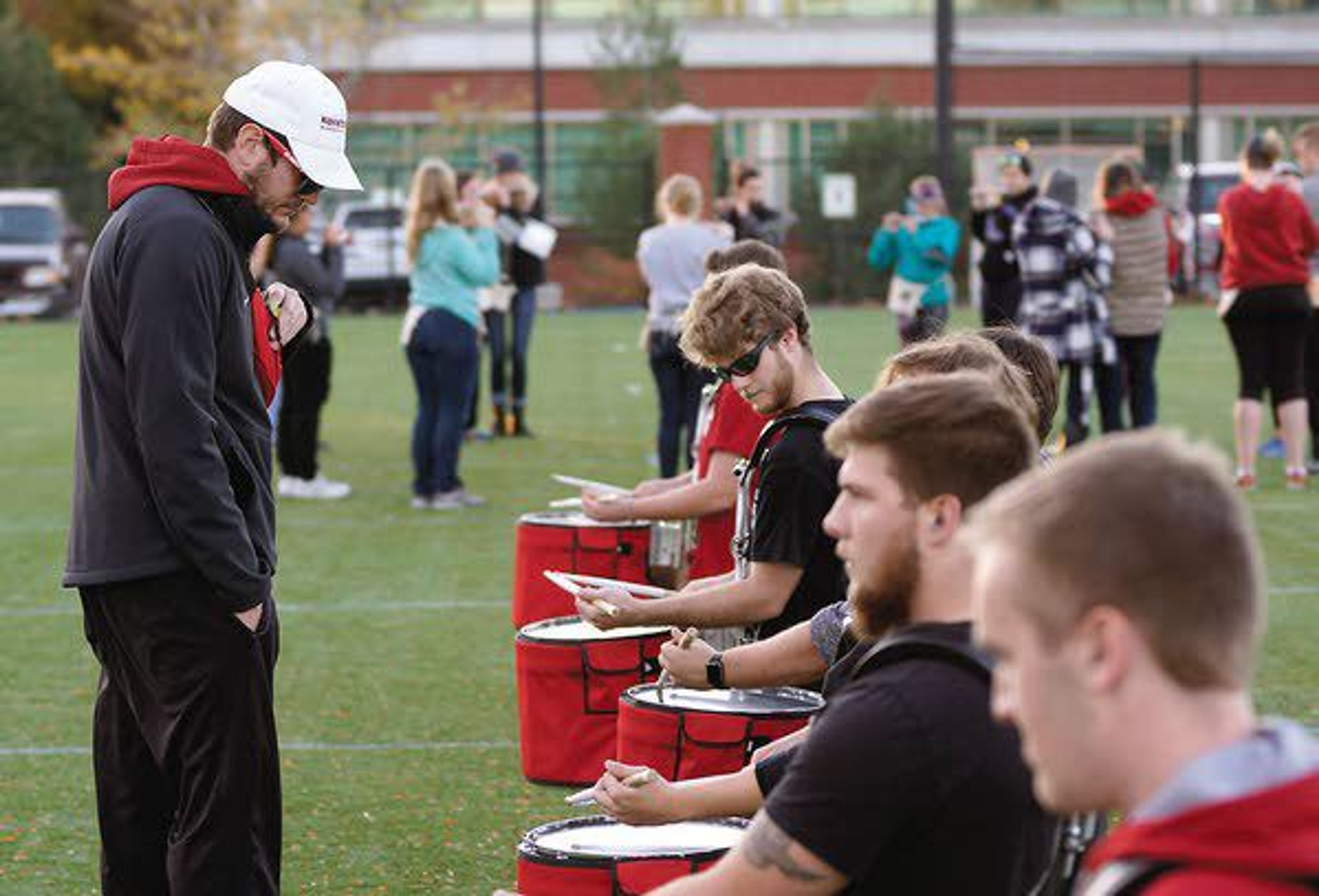 Washington State University Marching Band assistant director Brent Edwards, left, listens to the drumline during rehearsal October 24.