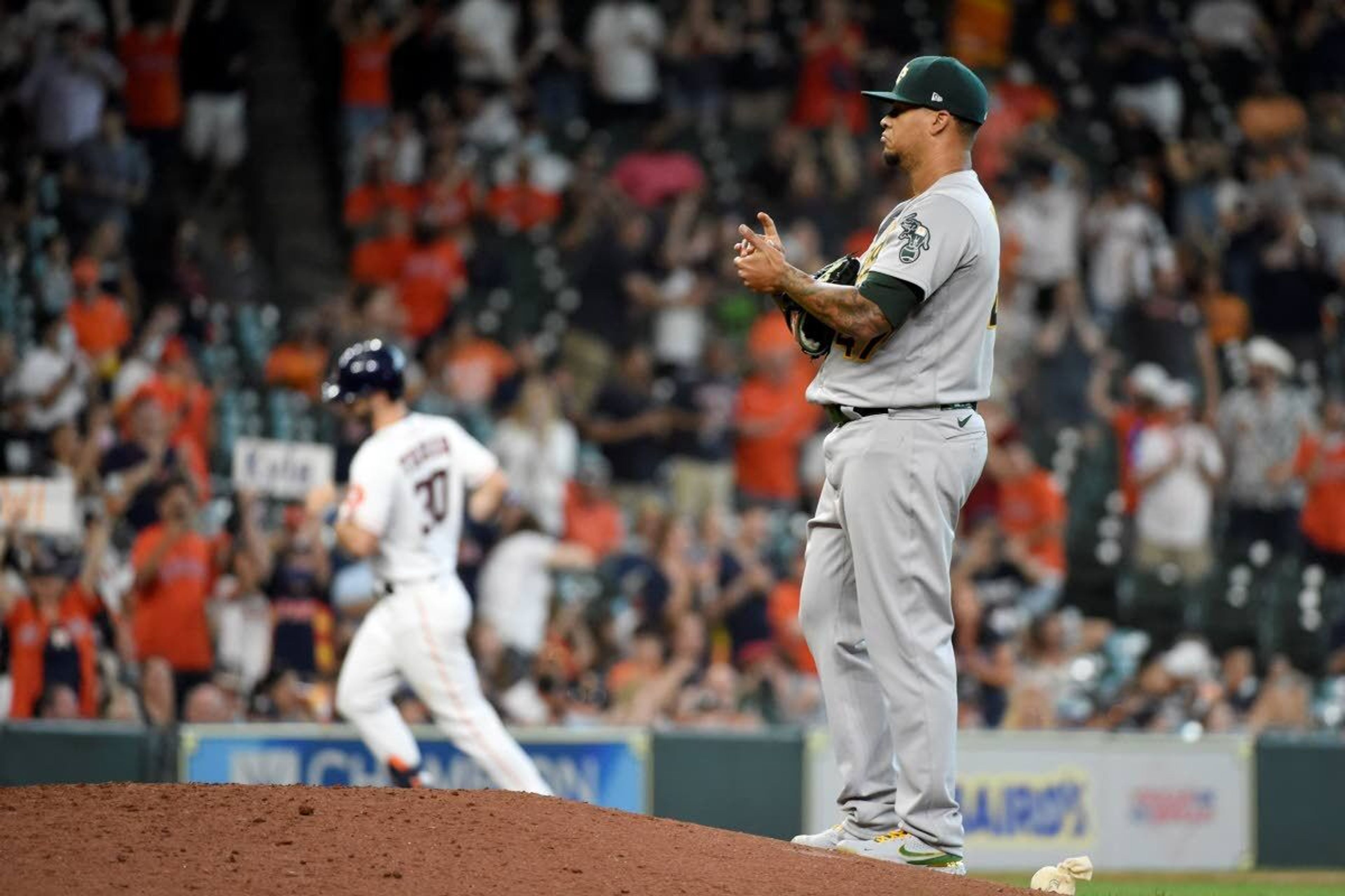 Oakland Athletics starting pitcher Frankie Montas, right, backs off the mound as Houston Astros' Kyle Tucker, back left, rounds the bases after hitting a solo run home run during the seventh inning of a baseball game, Saturday, April 10, 2021, in Houston. (AP Photo/Eric Christian Smith)