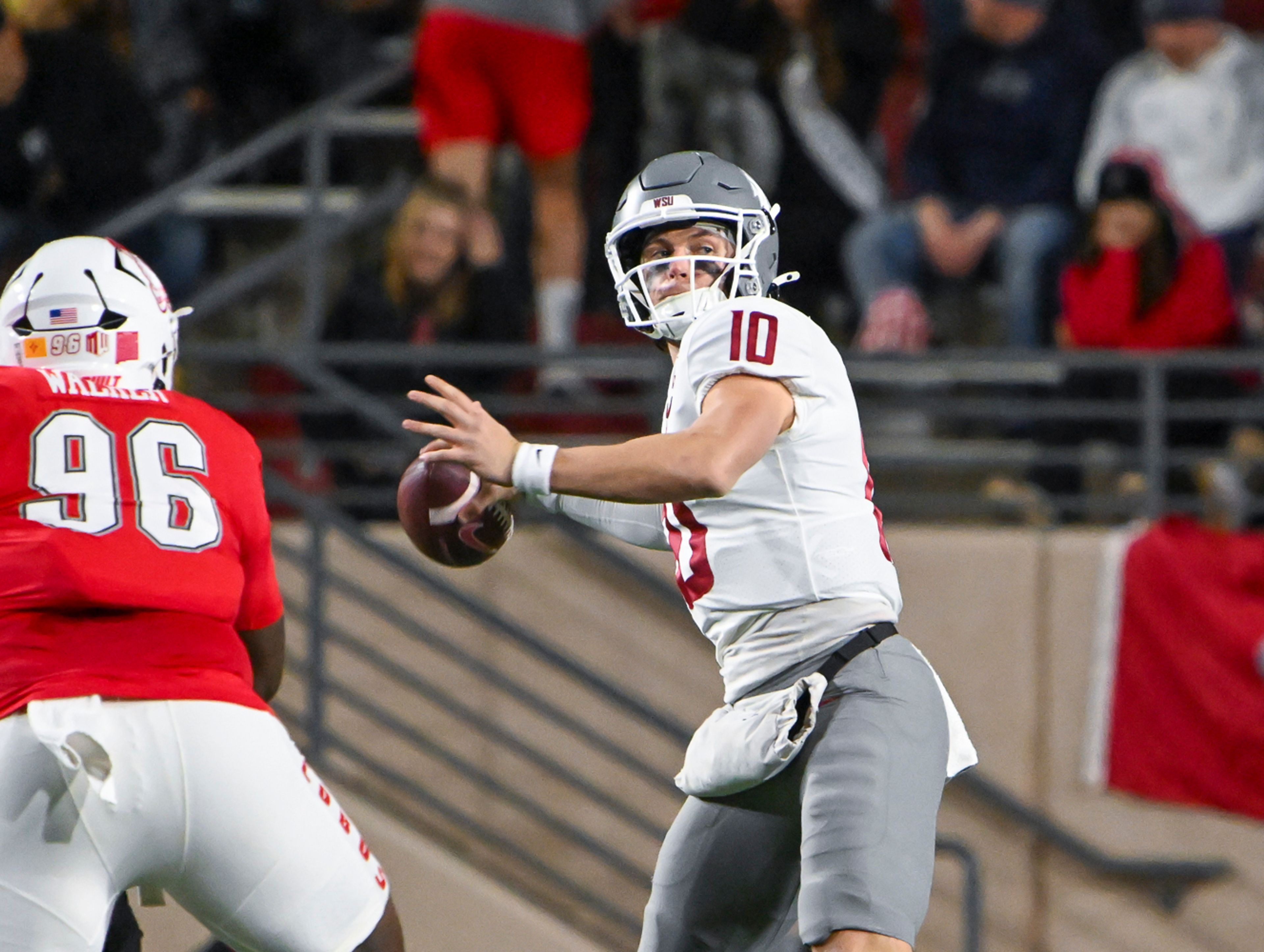 Washington State's quarterback John Mateer (10) looks to pass as he avoids the rush from New Mexico's Garrison Walker (96) during a game on Saturday, Nov. 16, 2024 in Albuquerque, N.M.