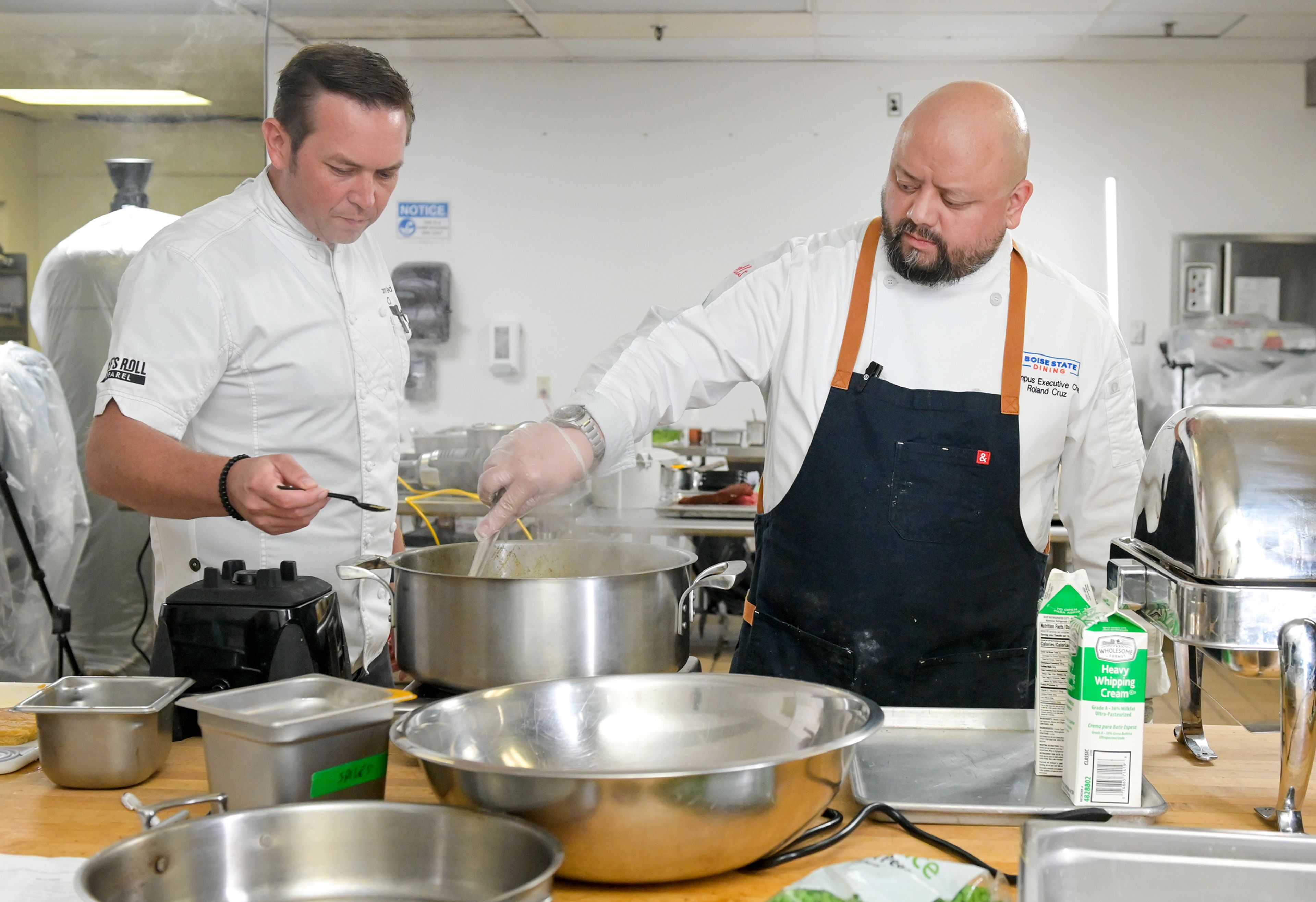 Chef Adam Hegsted, host of “Crave TV,” samples a dish being prepared by Chef Roland Cruz, an executive chef with Boise State Dining, during the Battle of the Chefs Wednesday at The Eatery on University of Idaho campus in Moscow.