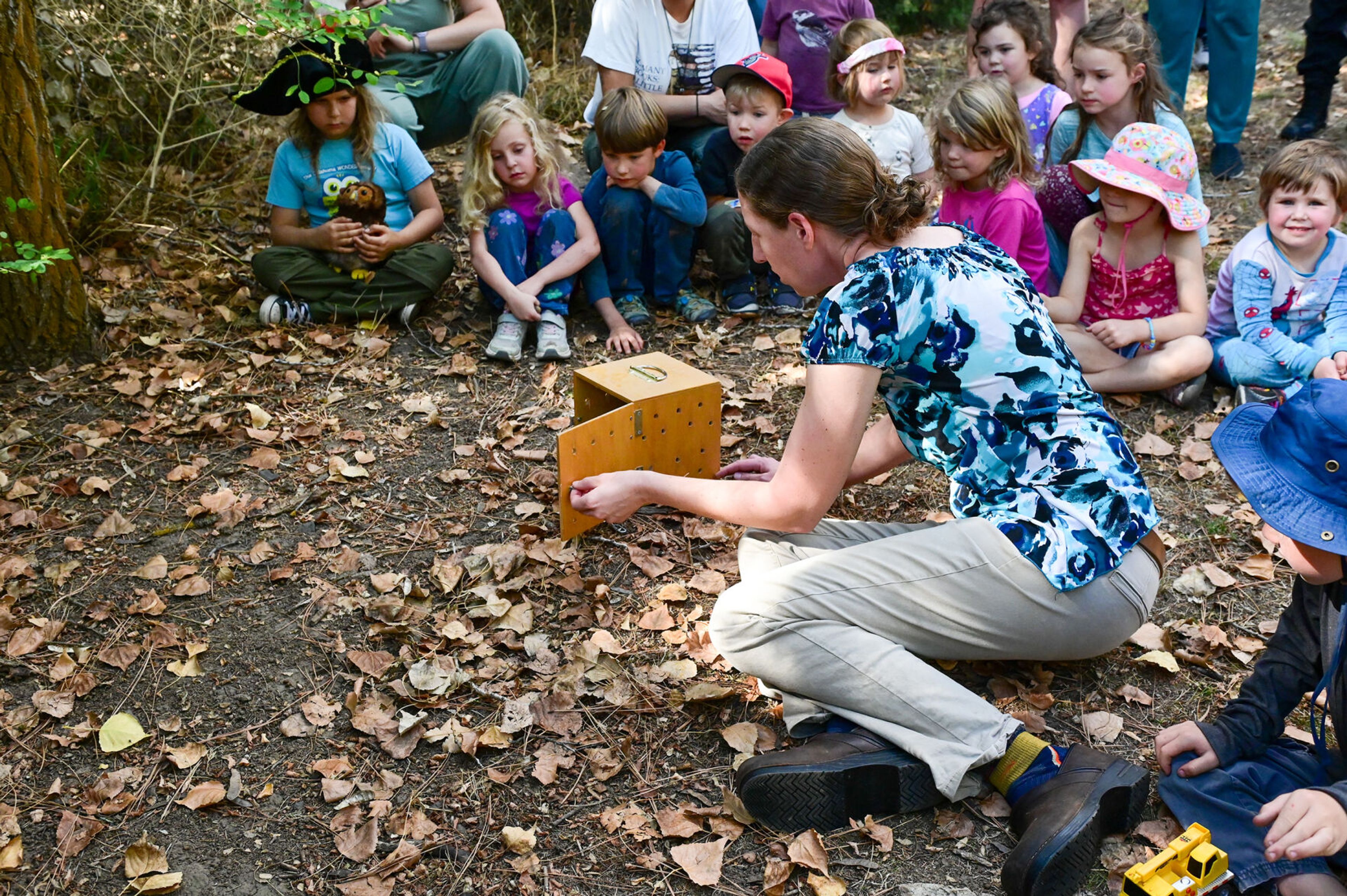 Students of Palouse Roots, Palouse-Clearwater Environmental Institute’s nature school, watch the release of a Western screech owl by Marcie Logsdon, right, a professor and wildlife veterinarian at Washington State University, Thursday at the nature center in Moscow.