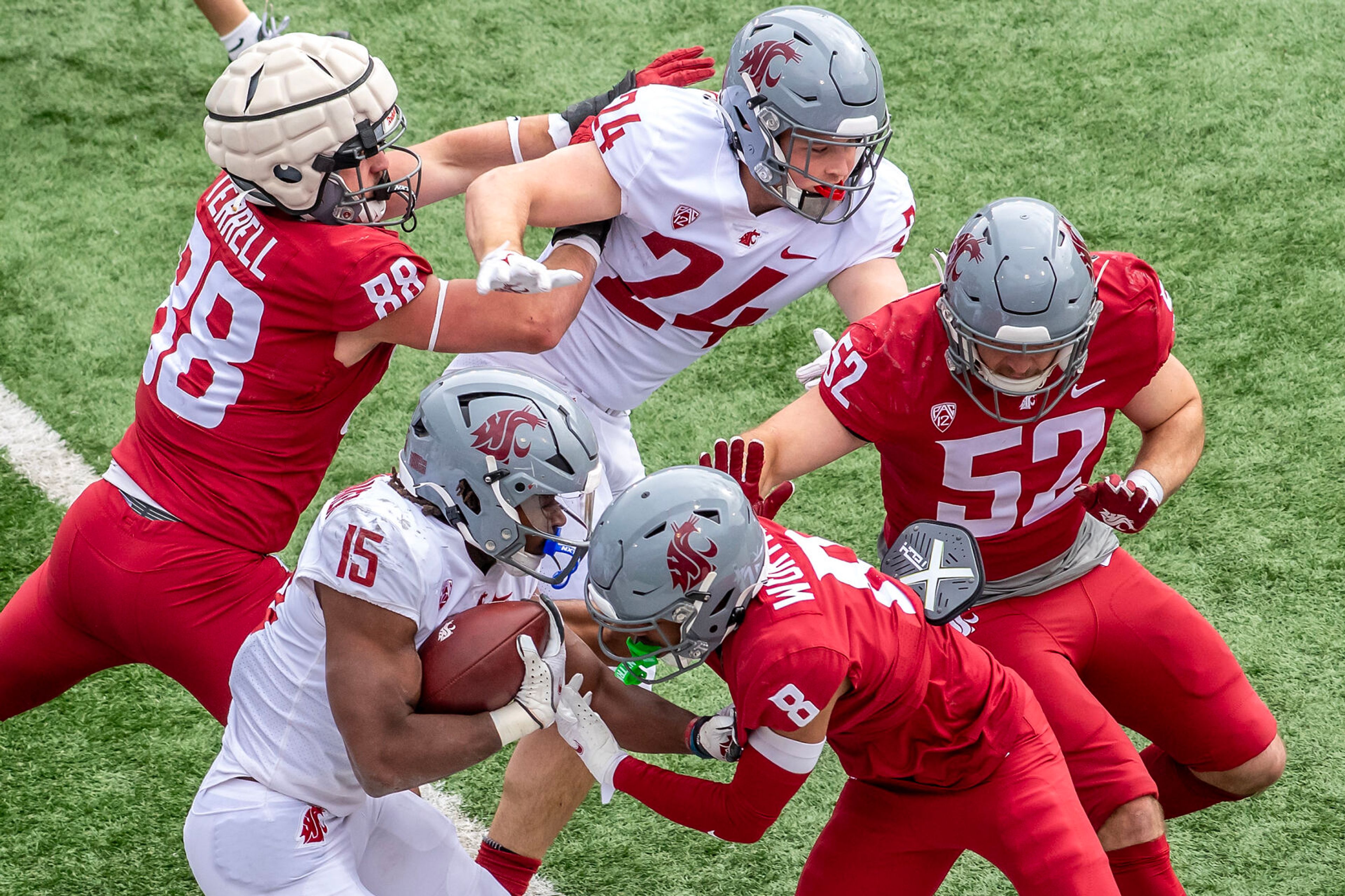 Gray running back Djouvensky Schlenbaker runs the ball as Crimson defensive back Kenny Worthy III tackles him in a quarter of the Crimson and Gray Game at Washington State University in Pullman.