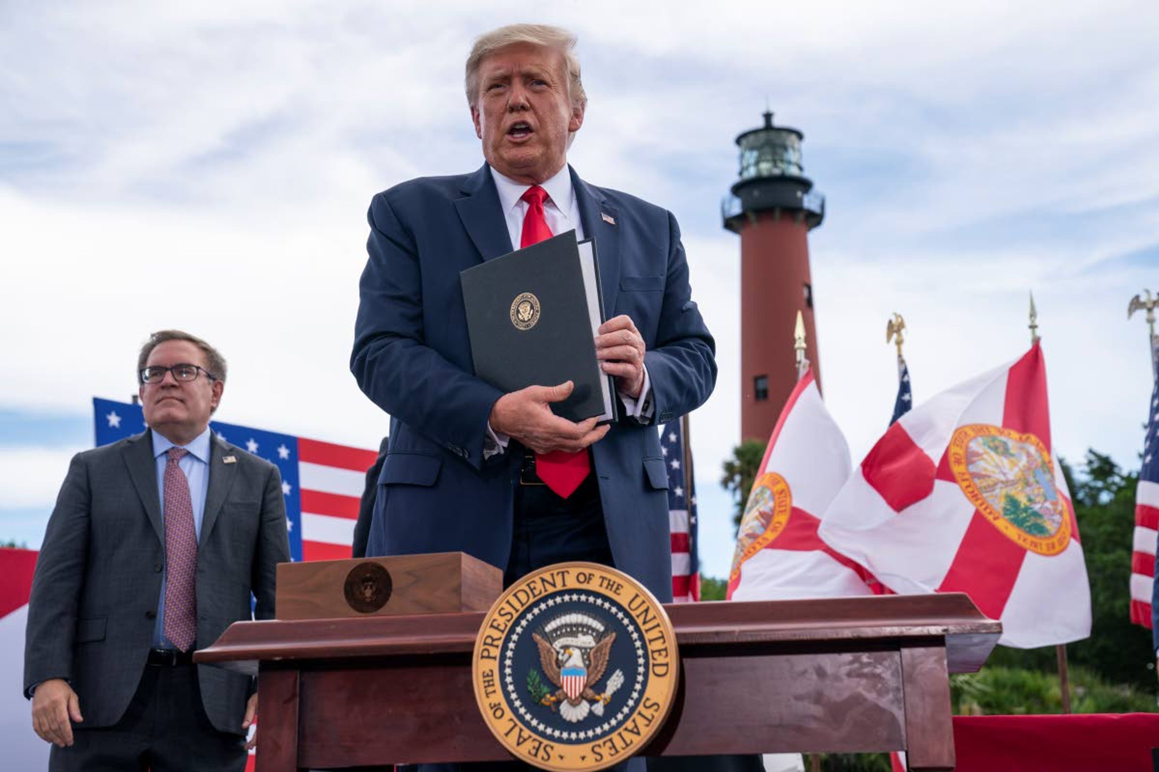 President Donald Trump shows off an executive order on protecting Florida coastline from offshore drilling after delivering remarks on the environment at Jupiter Inlet Lighthouse and Museum, Tuesday, Sept. 8, 2020, in Jupiter, Fla. (AP Photo/Evan Vucci)