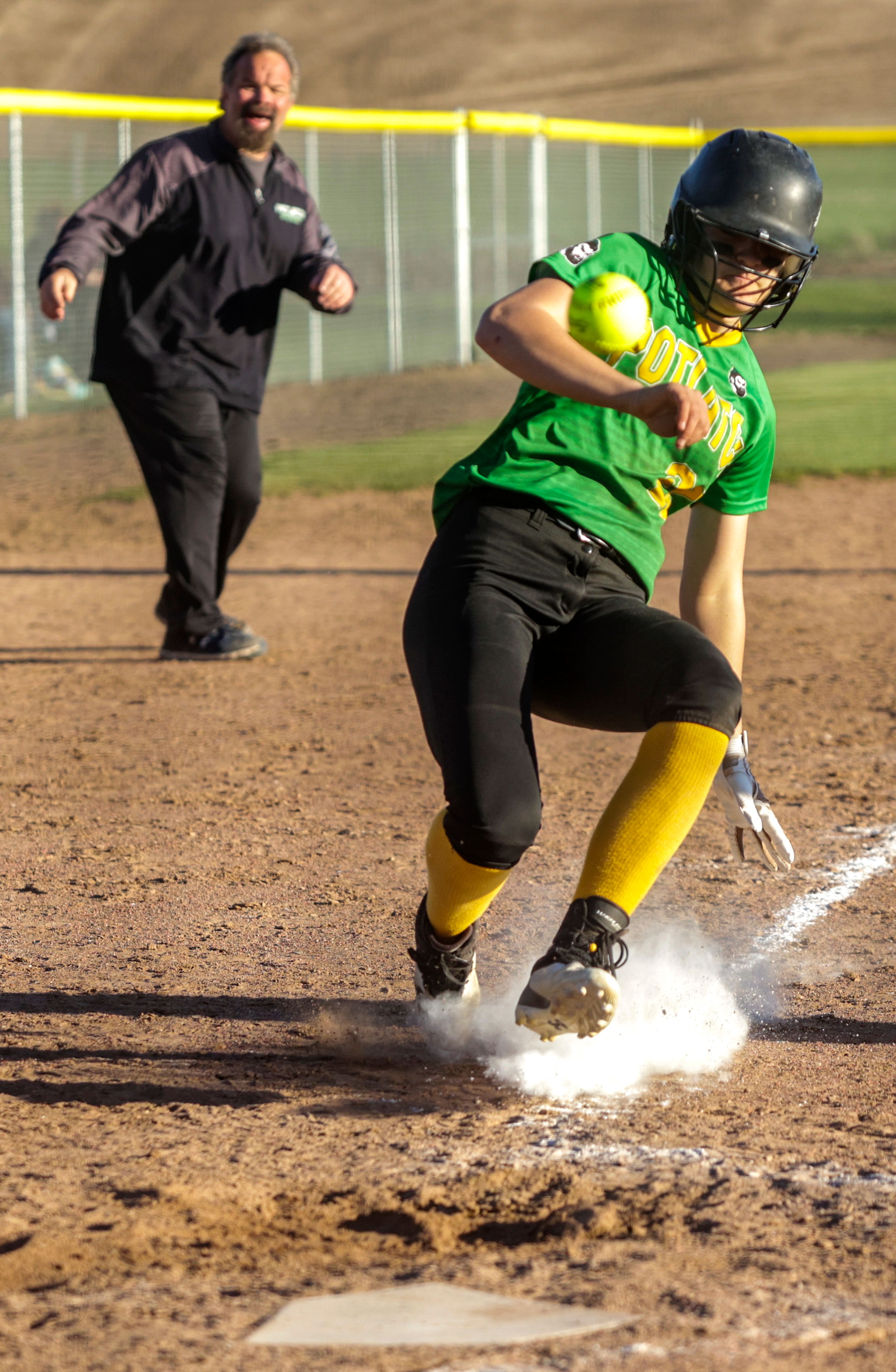 Potlatch High's Hayley McNeal goes into a slide as the ball passes in front of her as she comes into home. Potlatch defeated Kendrick 12-11 in the Class 1A district final in Genesee on Wednesday.