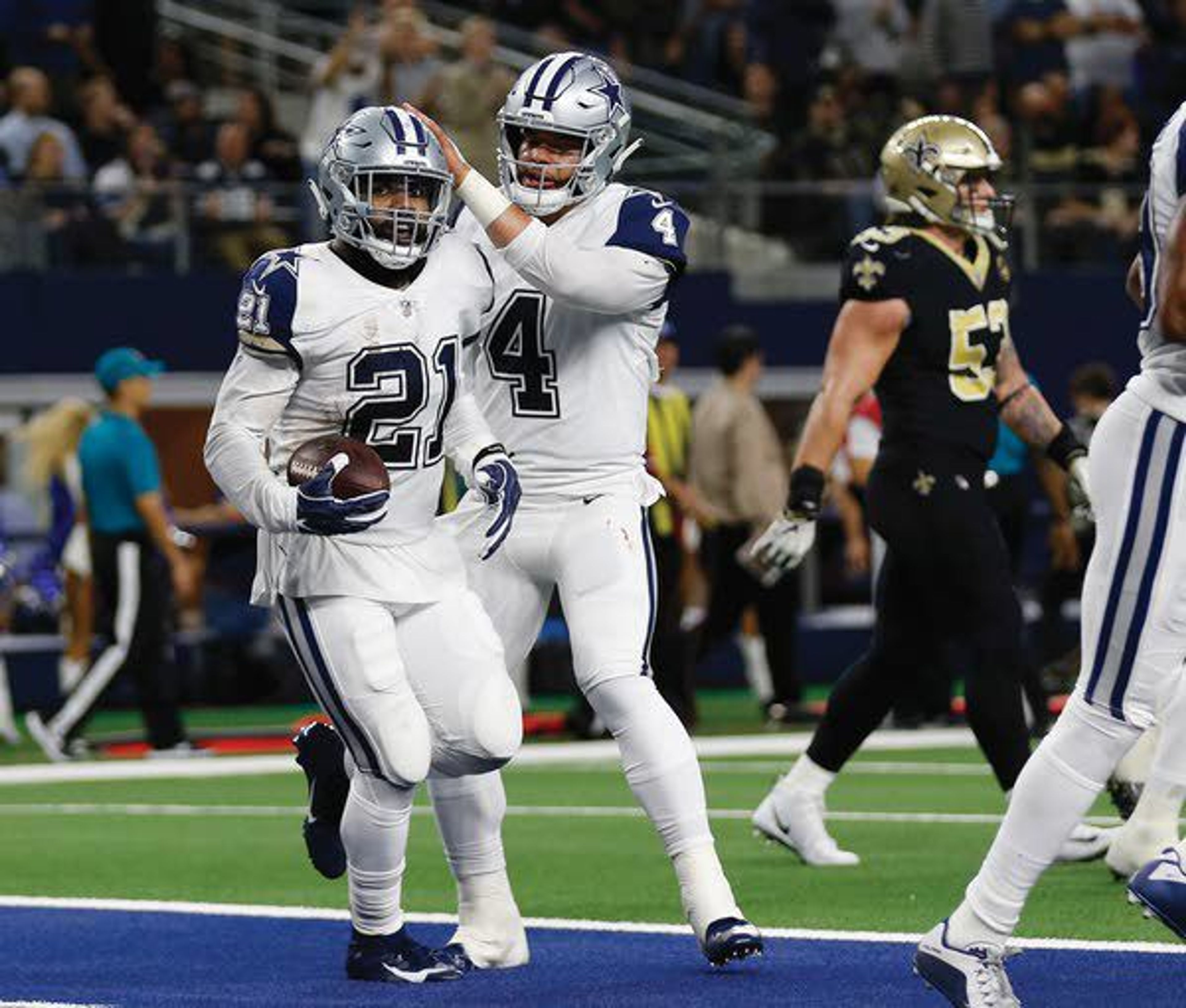 Cowboys running back Ezekiel Elliott (21) celebrates his touchdown against the Saints with quarterback Dak Prescott (4) in the first half of an NFL football game Thursday in Arlington, Texas.