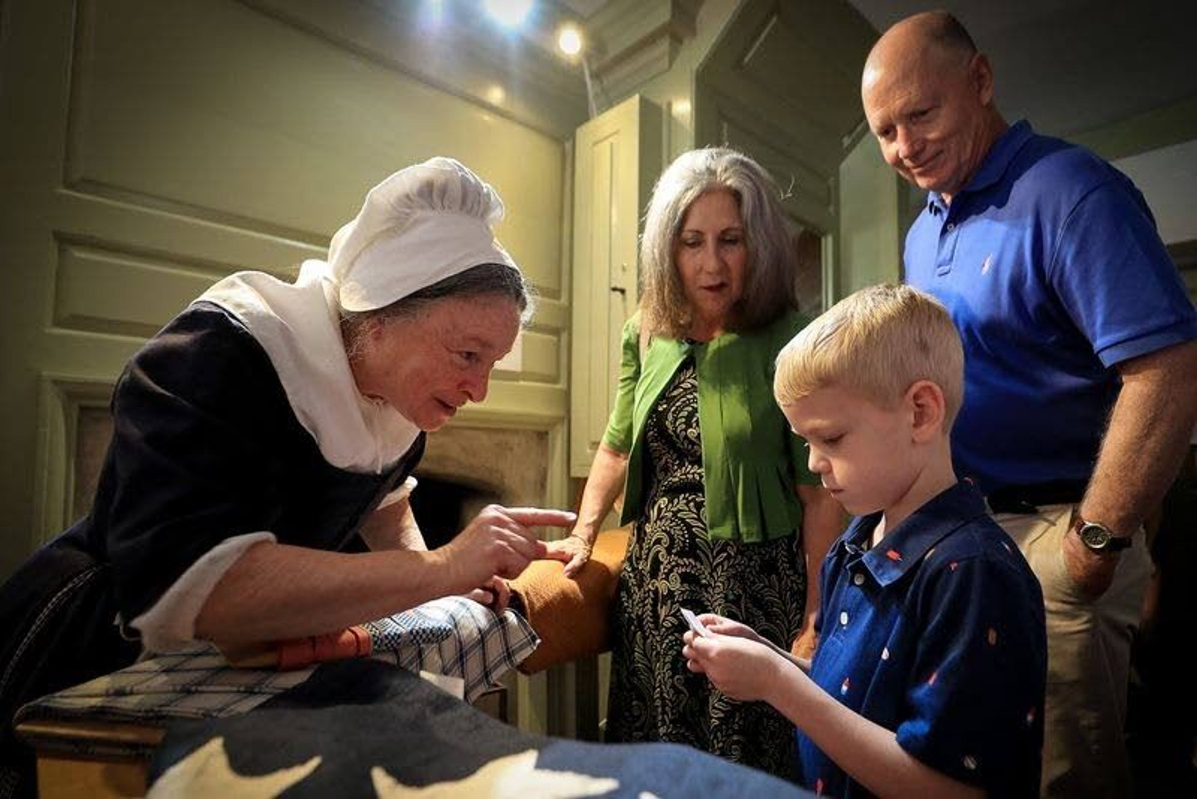 Carol Spacht, left, who portrays Betsy Ross, talks with Henry Driskell as his grandparents, Cecilia and Stephen Balderston, watch at the Betsy Ross House.