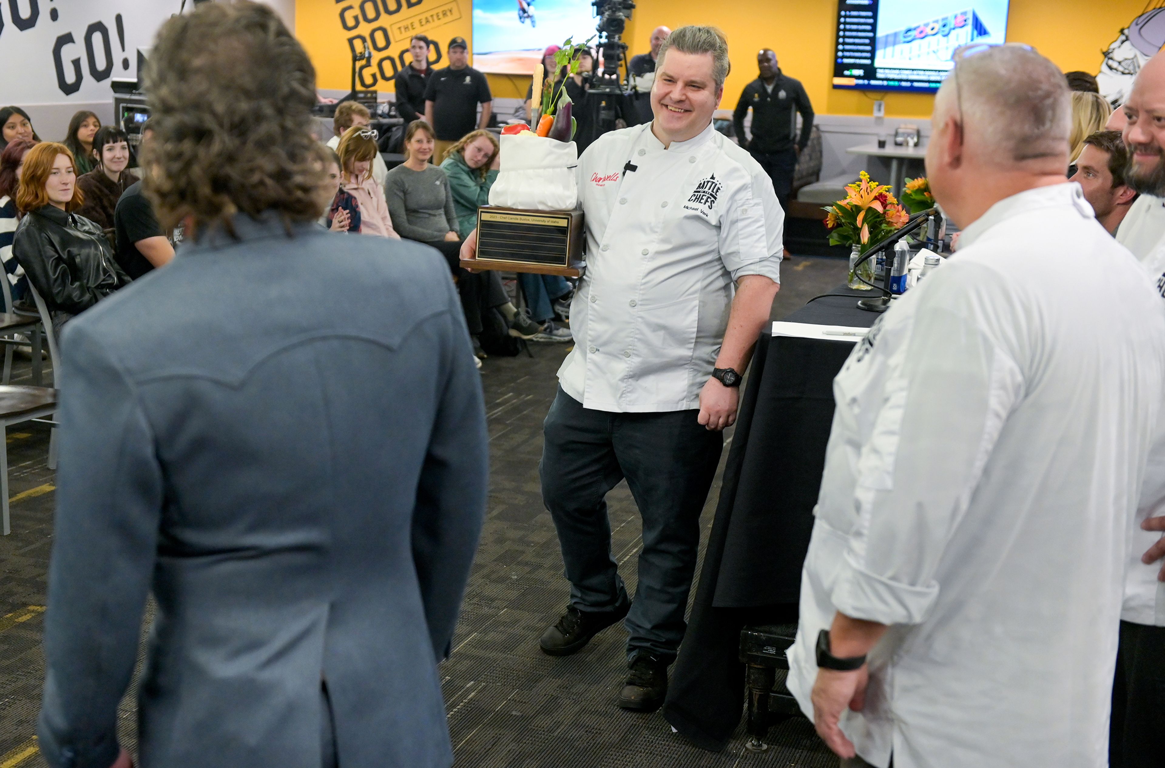 Chef Michael Verk, center, an executive chef with the University of Idaho’s Idaho Eats, carries the Battle of the Chefs trophy Wednesday after being awarded the winner of the competition at The Eatery on campus in Moscow.