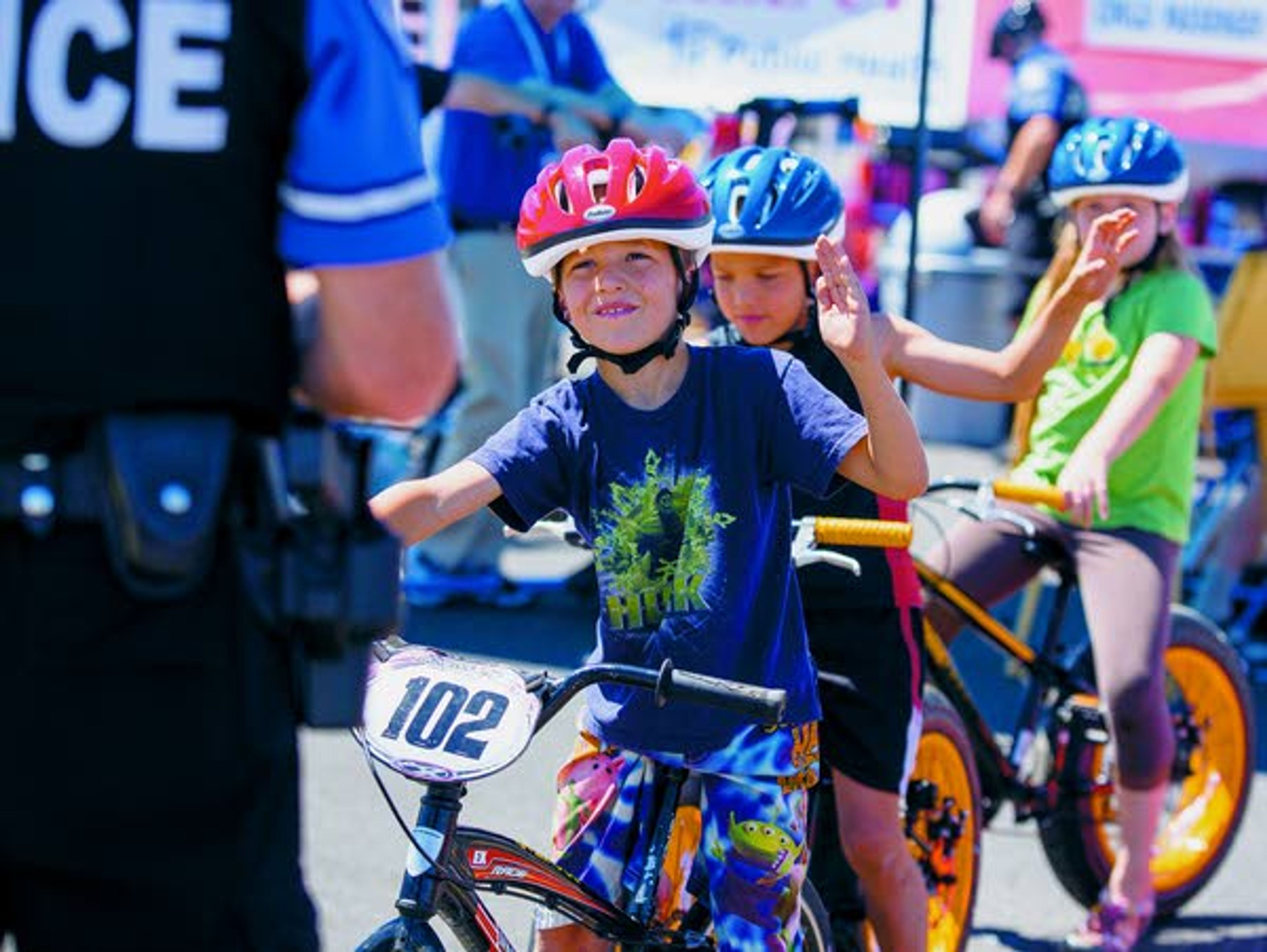 Angus Jordan, 9, of Uniontown (front to back), his twin brother, Wyatt, and sister Emily, 11, practice turn signals with officer Dennis Pratt, left, during the first Pullman Police Department Bike Rodeo on Saturday at the Wal-Mart in Pullman. The PPD plans to make this an annual event.