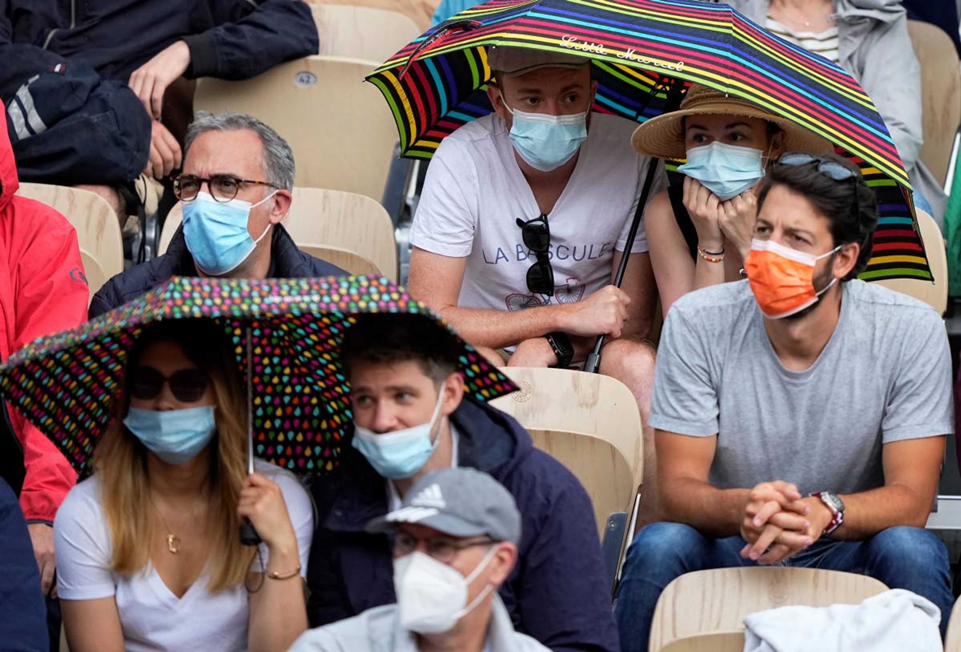 Spectators on the Simonne Mathieu court put up umbrellas as rain falls while they watch Japan's Kei Nishikori play against Switzerland's Henri Laakosonen during their third round match on day 6, of the French Open tennis tournament at Roland Garros in Paris, France, Friday, June 4, 2021. (AP Photo/Michel Euler)