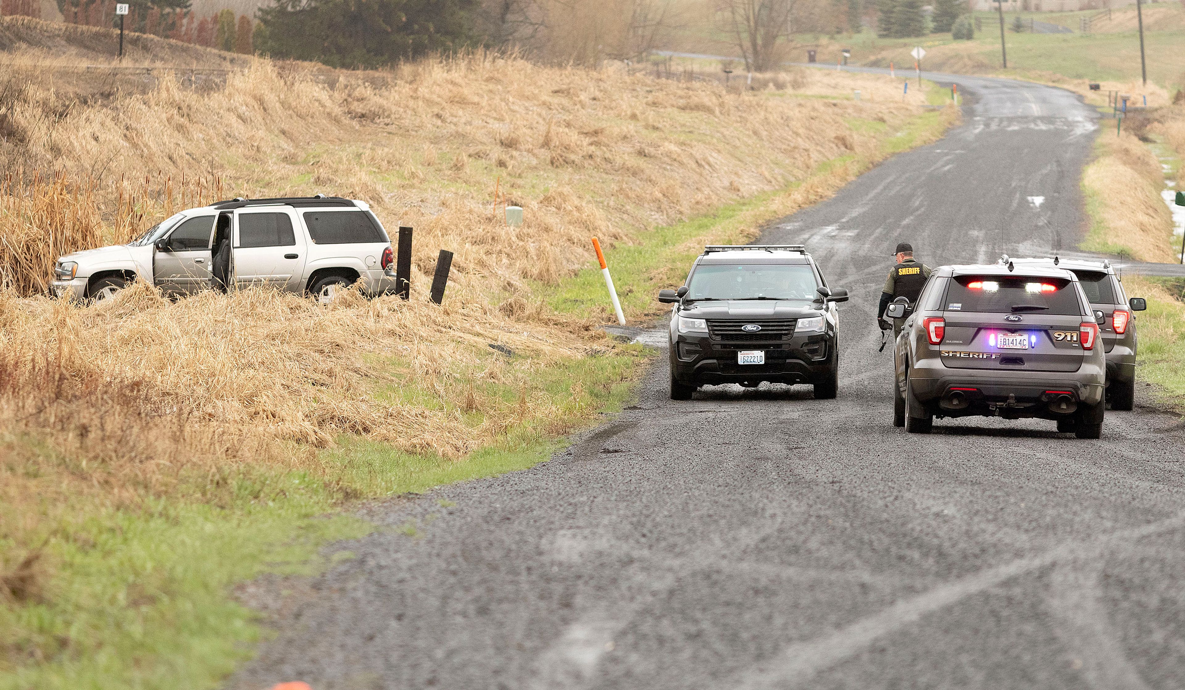 Law-enforcement officers investigate a stolen Chevrolet Blazer that was found abandoned on Sunshine Road on Monday east of Pullman. The vehicle was stolen from an employee of Bud Hut by a man who robbed the store at gunpoint.