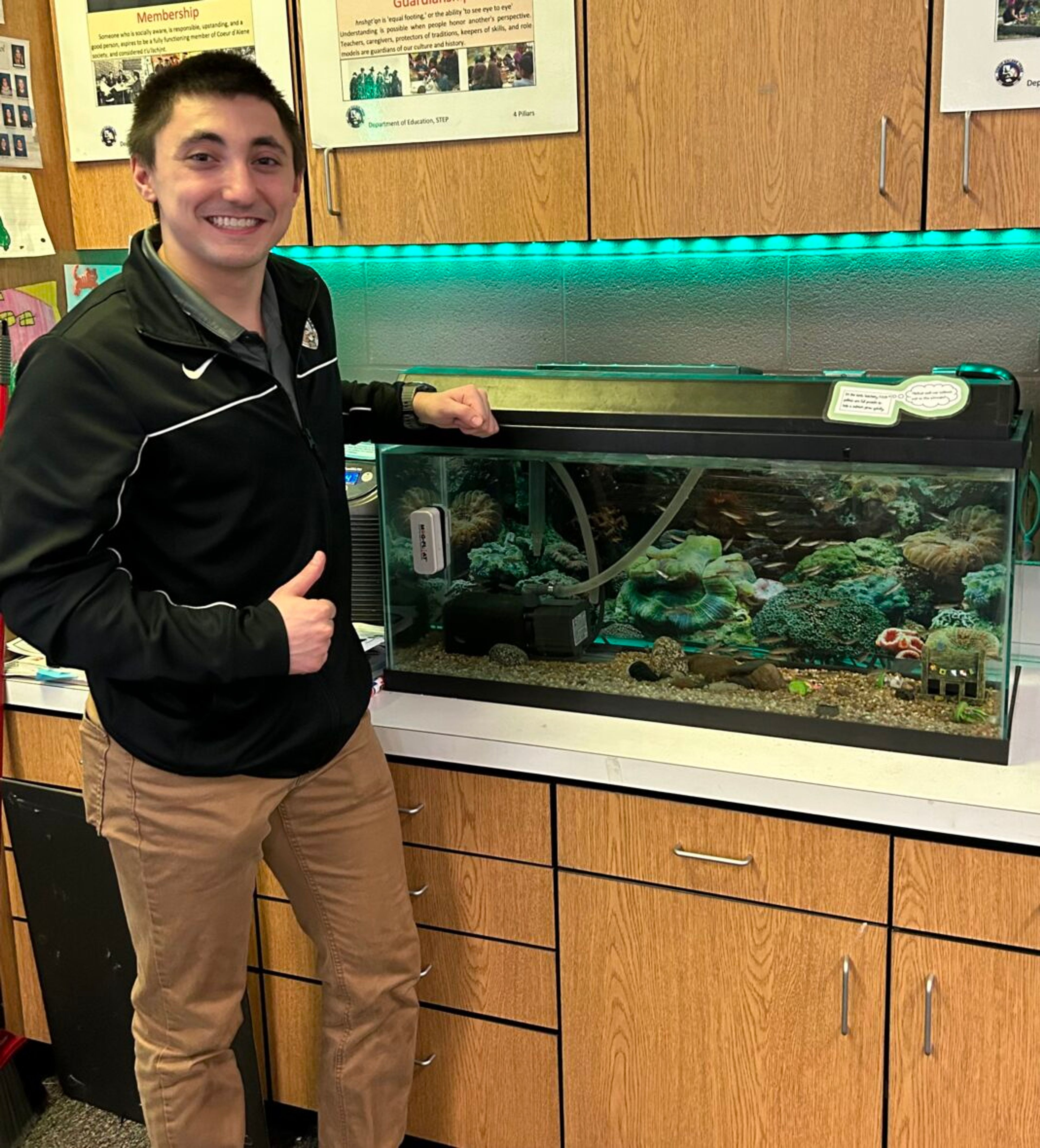 Nicholas Eldredge, a fourth grade teacher at Coeur d’Alene Tribal School, stands near fish that his class will raise and release. Eldredge is a graduate of the University of Idaho’s IKEEP program.