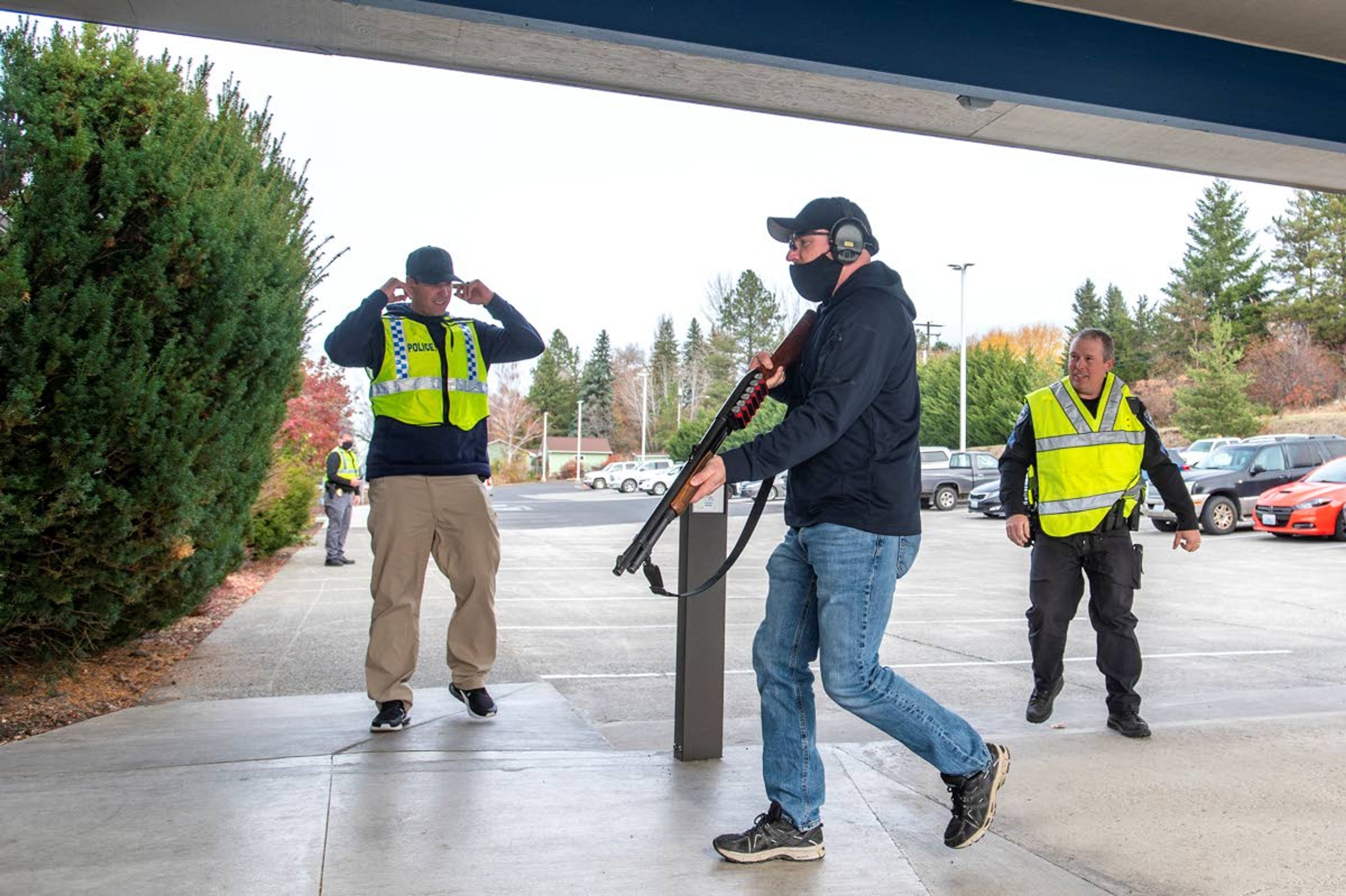 Officer Ruben Harris, of the Pullman Police Department, portrays an attacker carrying a shotgun as he enters Pullman City Hall during active shooter training Wednesday afternoon.